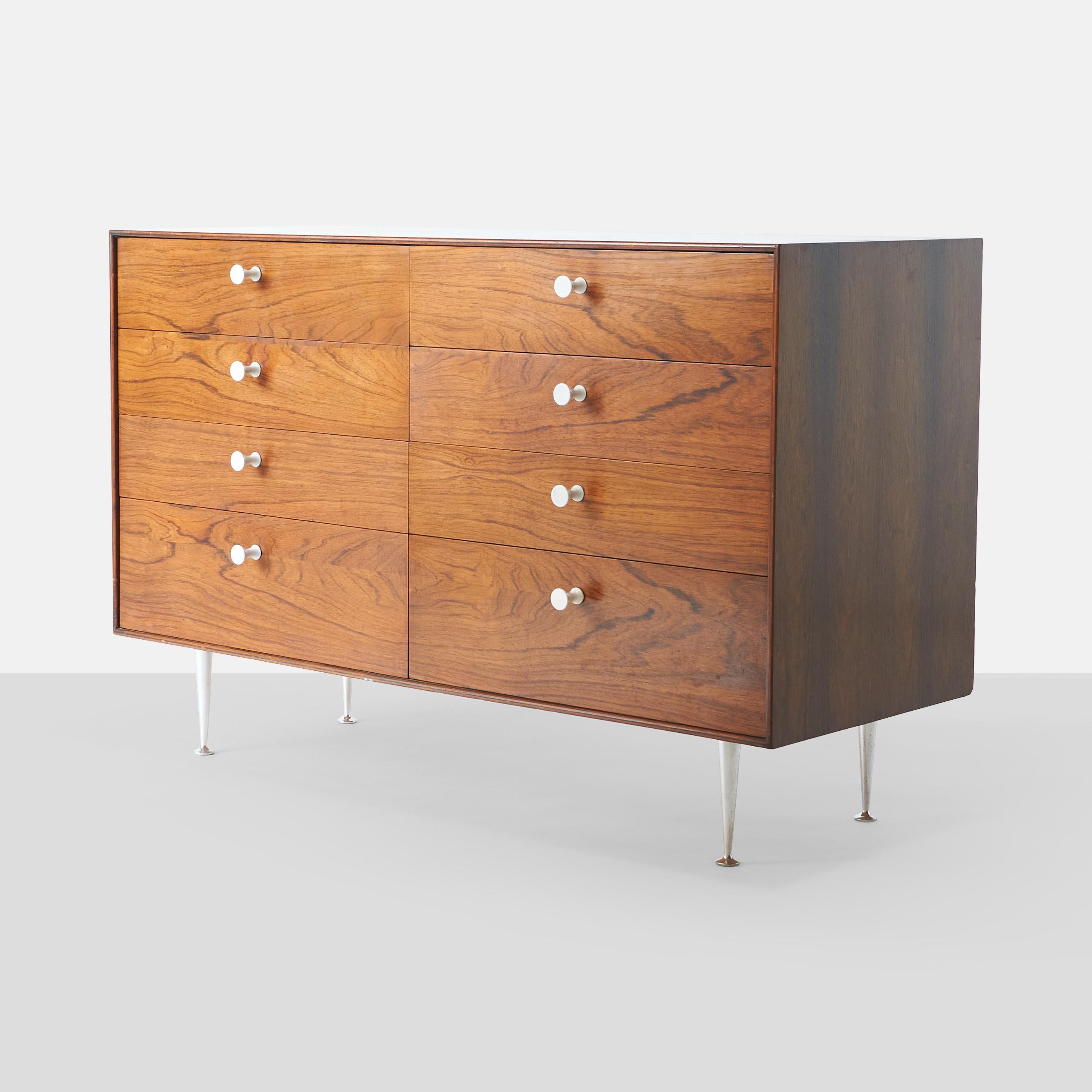 A chest of drawers by George Nelson for Herman Miller in rosewood, with porcelain knobs and aluminum fluted legs. The top drawers have dividers.

Retains the manufacturer’s label.[George Nelson Design Herman Miller Zeeland Michigan].