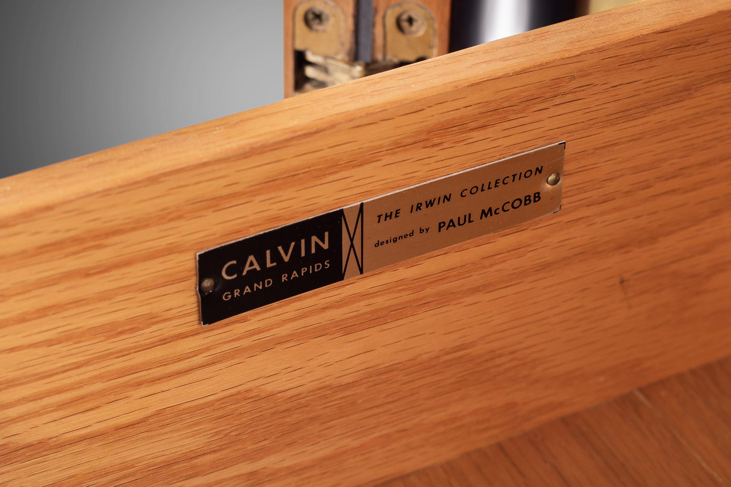 An exceptional Mid-Century Modern sideboard credenza or bar cabinet designed by Paul McCobb for his Irwin collection line for Calvin Furniture. The cabinet features stunning Honduran mahogany wood grain and sleek mid-century lines. An excellent