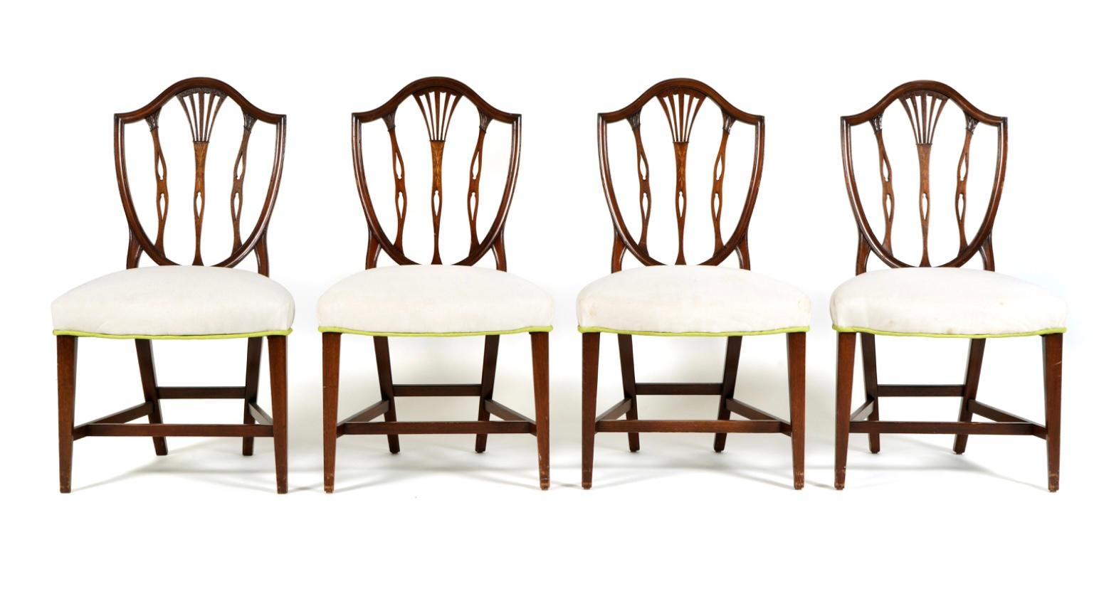 Set of eight late 19th century Hepplewhite dining chairs, two chairs with arms and six side chairs. Chairs are carved and molded with American shield backs with center floral inlay. White linen upholstery. Purchased at Sotheby's in 1977. 