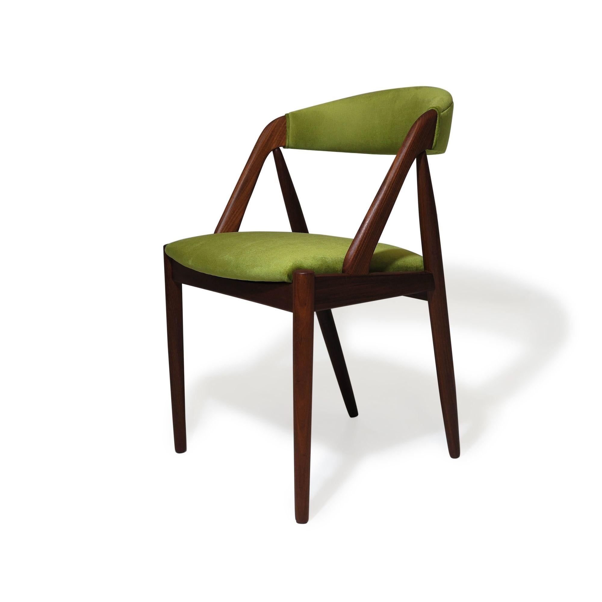 midcentury Danish dining chairs designed by Kai Kristiansen for Schou Andersen, Model 31. The chairs feature solid walnut frames with comfortable and supportive back rests; newly upholstered in a lime green velvet upholstery, over new foam and new