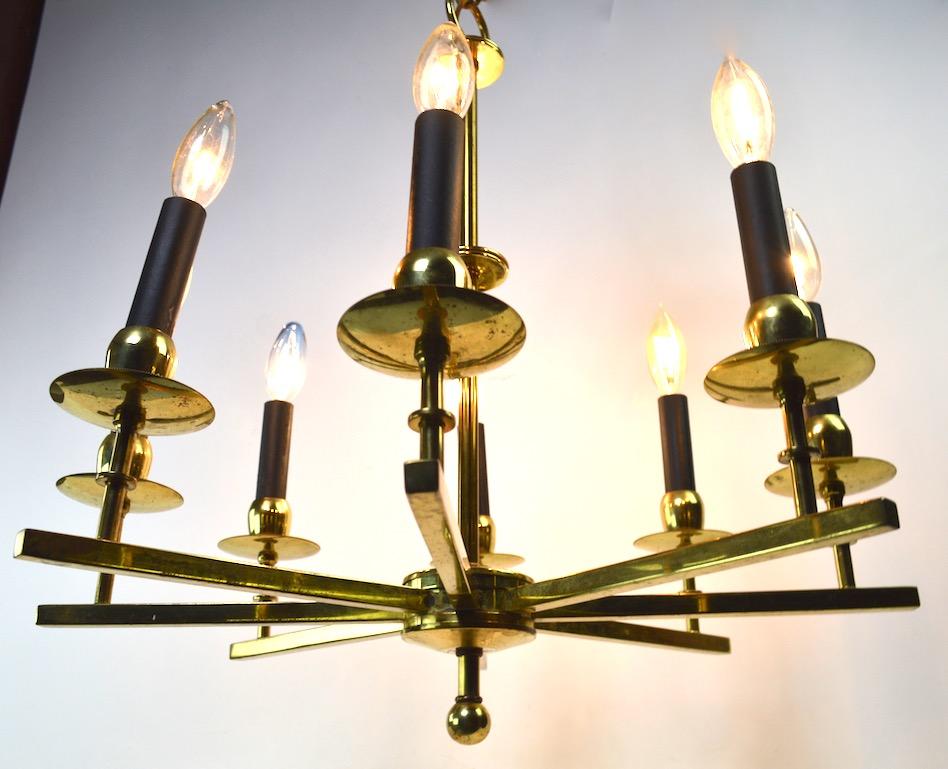 Stylish brass spoke style hanging fixture, in original and working condition. The chandelier shows some cosmetic wear to the finish, normal and consistent with age. Measures: Height (22 inches), does not include the chain or canopy.