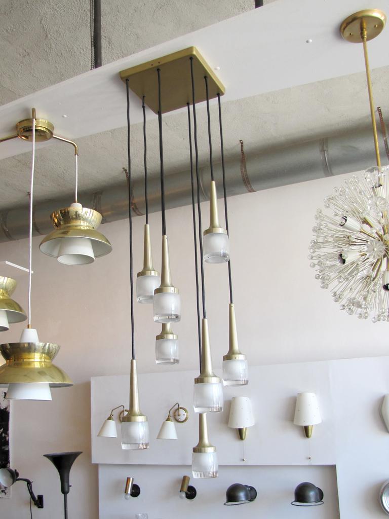 Stunning eight hanging lights by Staff of Germany, encased in heavy molded glass, brushed brass, lengths and configuration adjustable, currently in square brass canopy, can be hung individually, wired for US standards, eight E12 sockets, max.