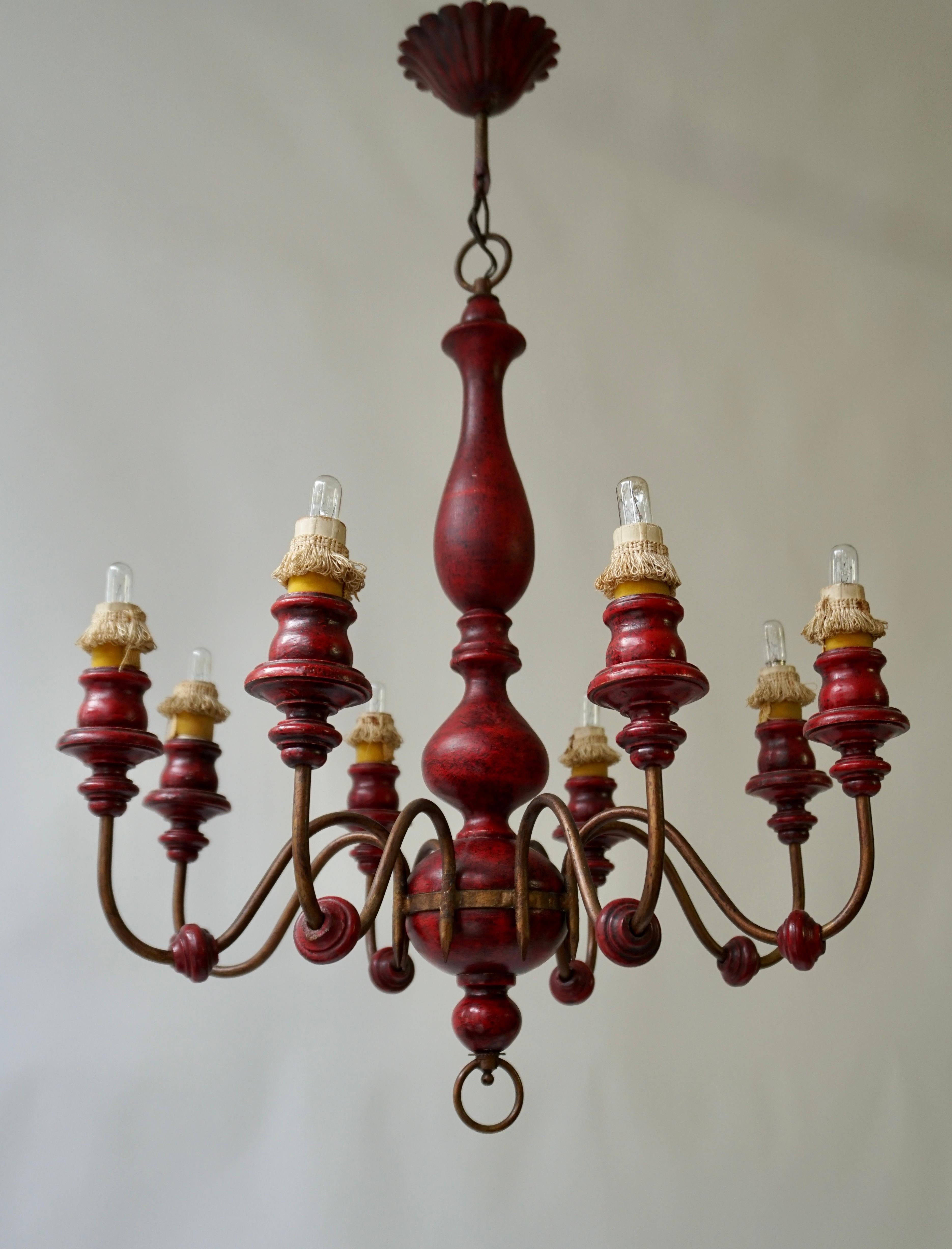 Beau lustre italien en bois peint en rouge avec huit bras en métal.

Diamètre 53 cm.
Hauteur de la fixation 62 cm.
Hauteur totale 75 cm.

La lampe nécessite huit ampoules à vis E14 (40Watt max.) compatibles avec les LED.
