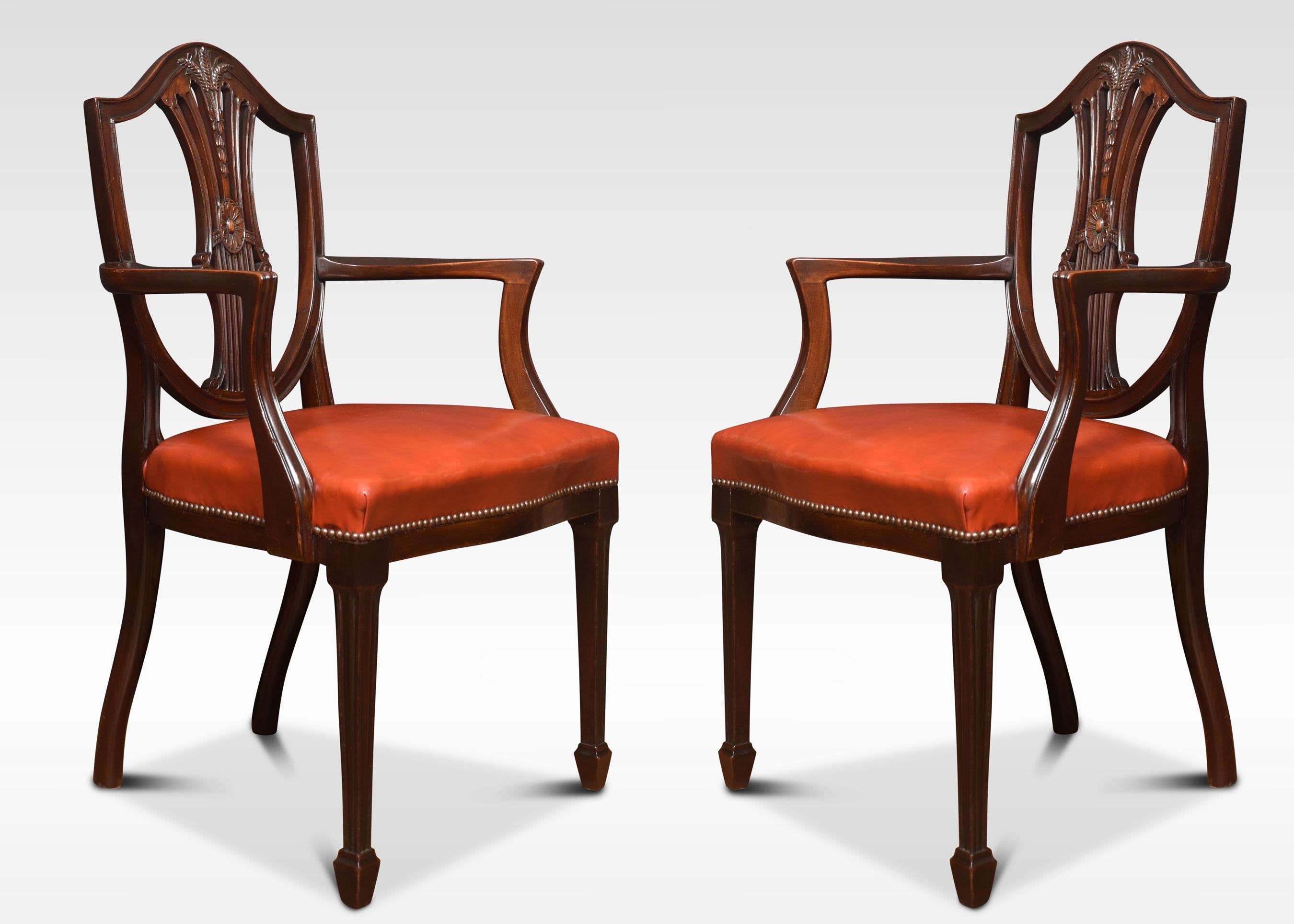 A set of eight mahogany (six chairs two carvers) Hepplewhite style dining chairs with pierced wheatsheaf carved splats above overstuffed leather seats. All raised up on square tapering legs terminating in spade feet.
Measures: Armchairs
Height 38