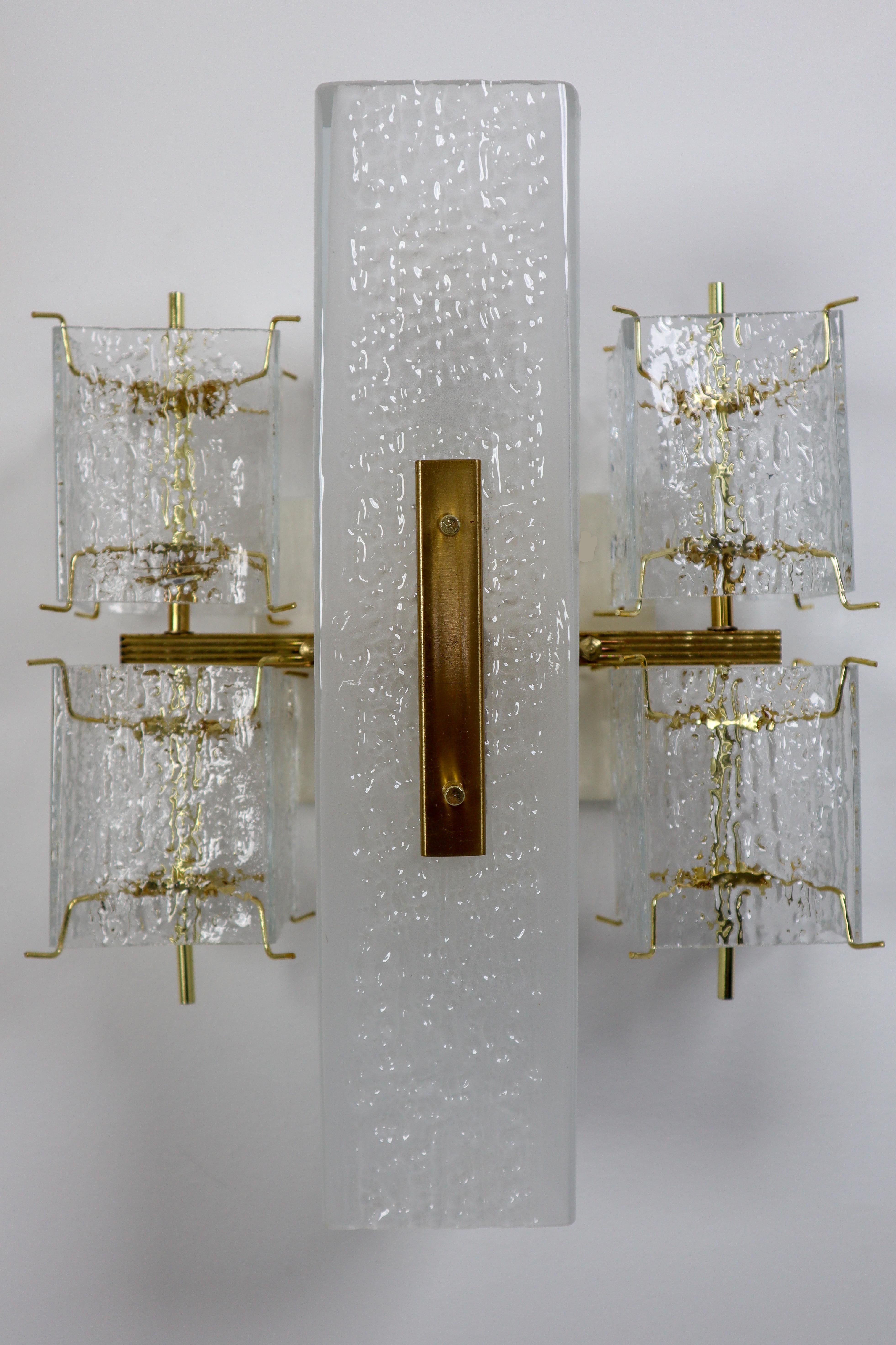 Eight midcentury wall lights, in glass and brass, Europe, 1970s. 

This elegant square wall lights features four small rectangular structured glass shades and a rectangular opaque middle section. The frame is made of brass and holds small brass