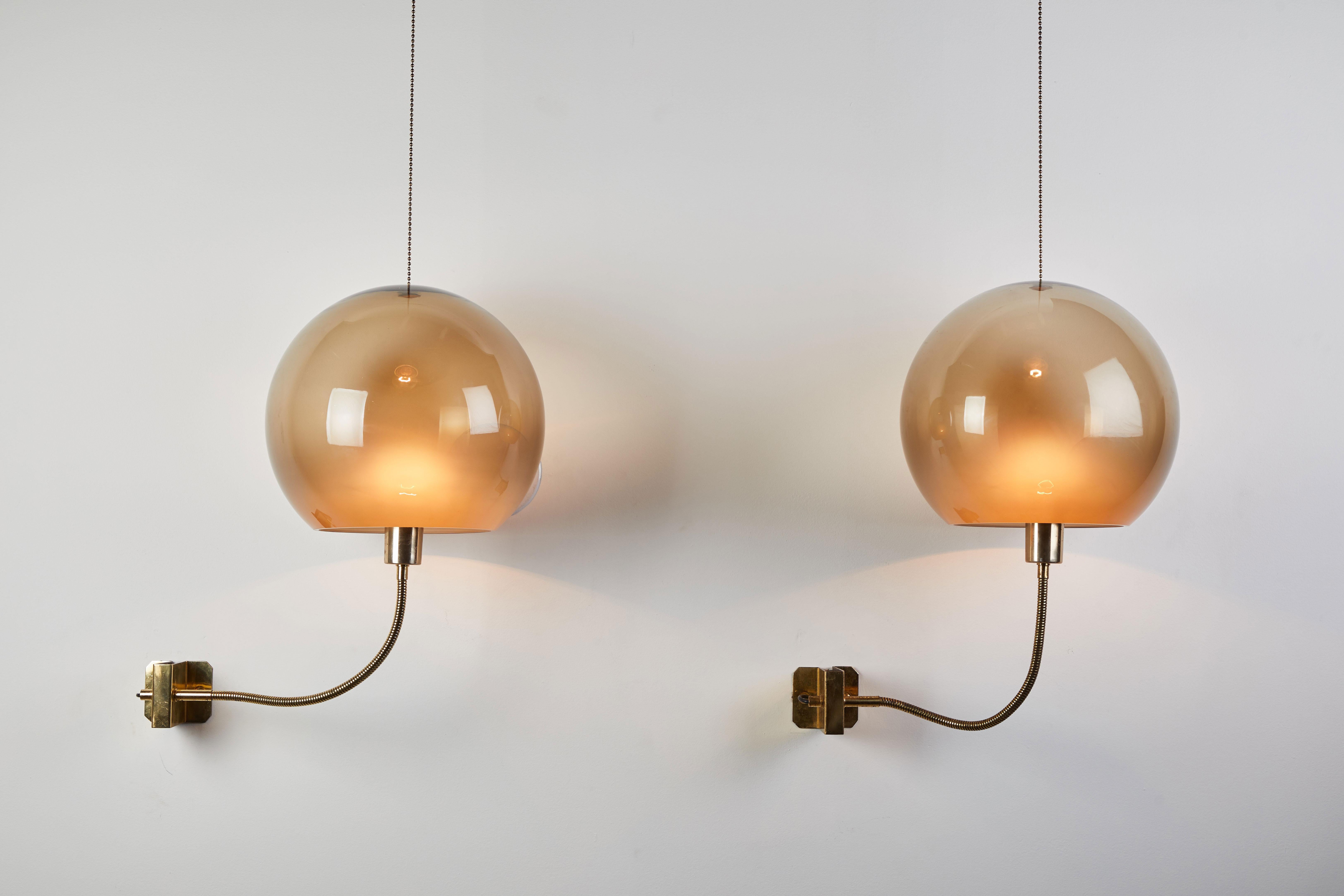 Two rare and important model 244 sconces by Ico Parisi for Arteluce. Designed and manufactured in Italy circa 1960. Brass and glass. Wired for US junction boxes. This ingenious design allows light source to be directed on a flexible arm or diffused