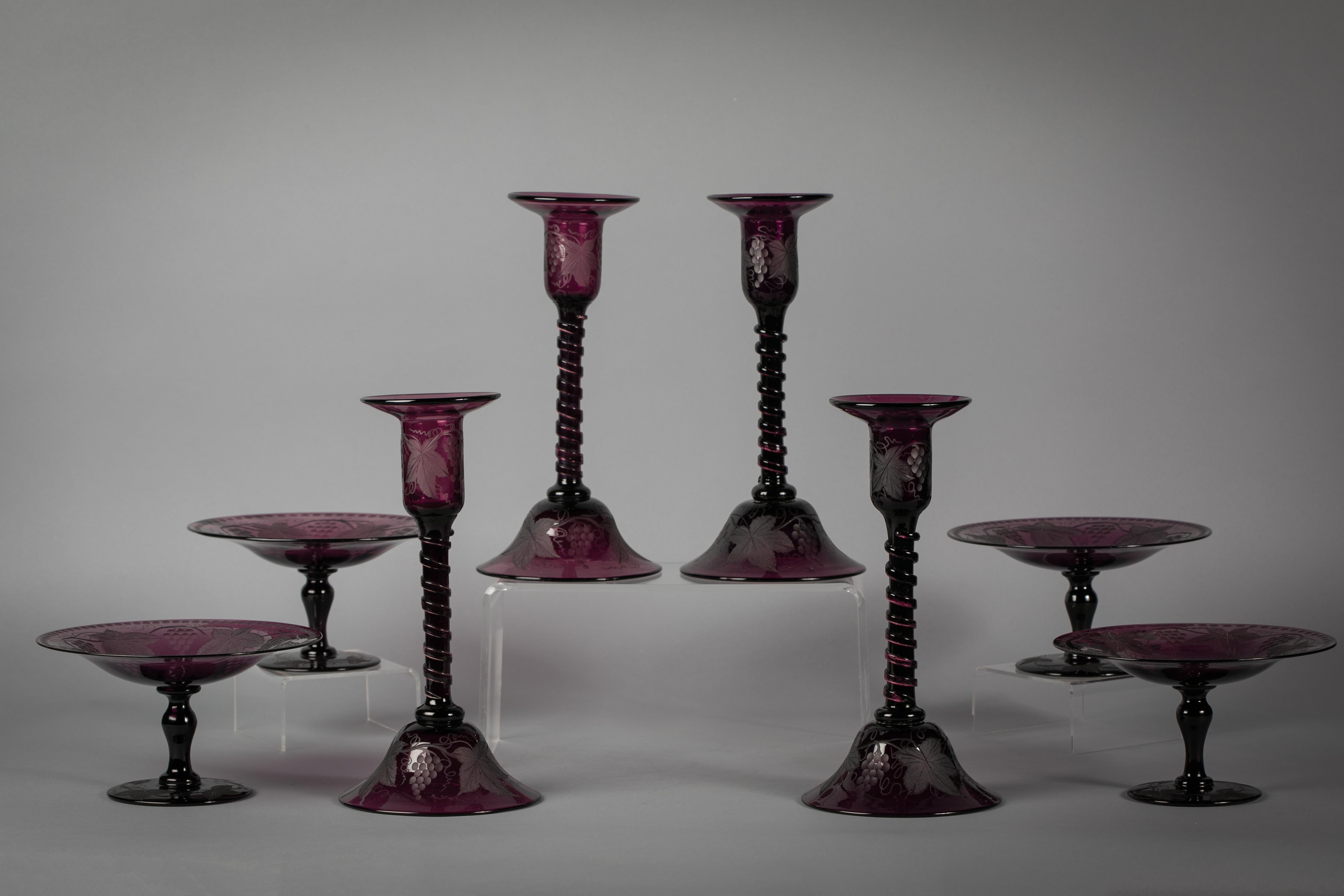 Comprising a set of four candlesticks and four compotes. With a polished amethyst ground and grape, vine and leaf engraving.