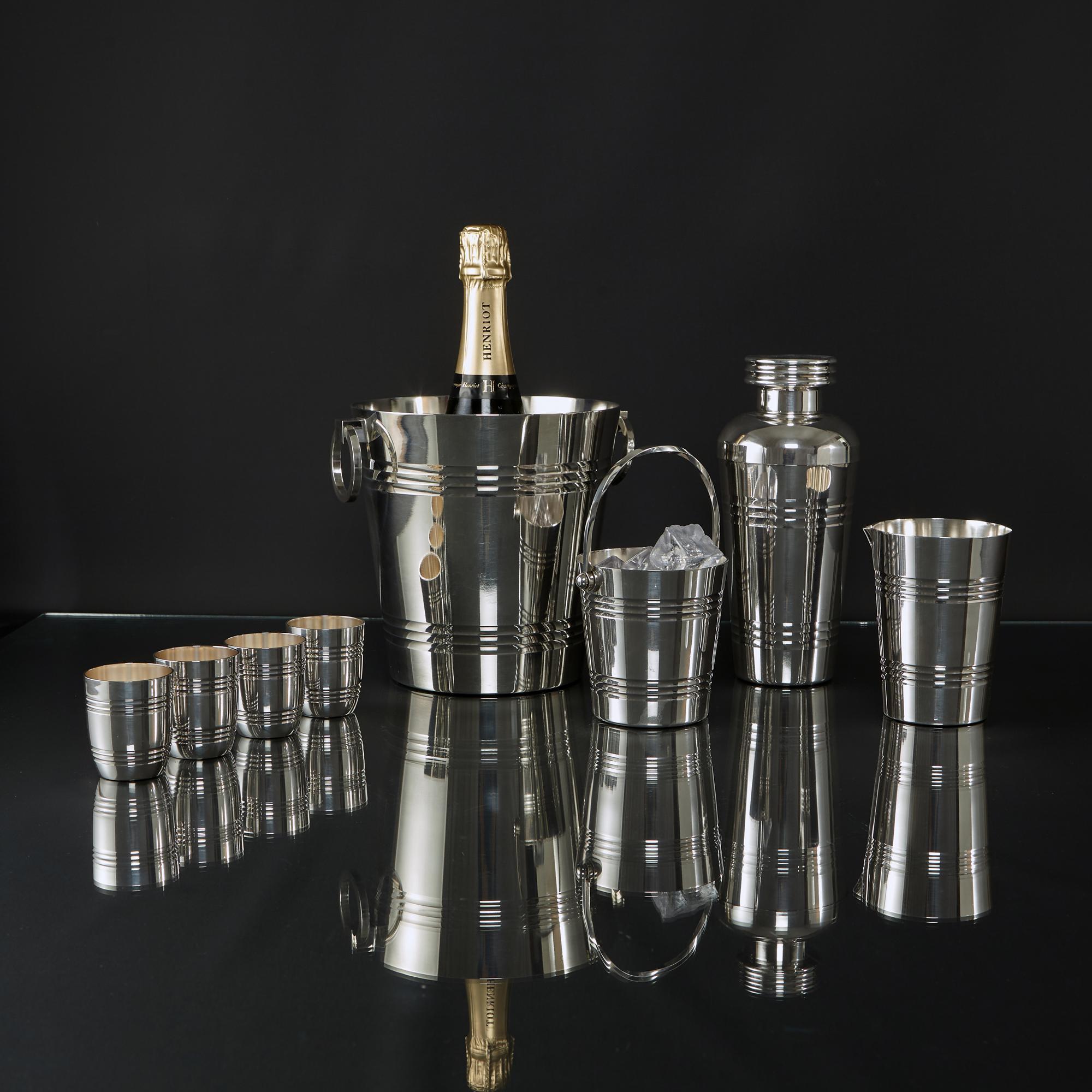 With distinct Art Deco design cues, this eight-piece French silver-plated cocktail or barware set comprises an ice bucket, cocktail shaker, ice pail, mixing jug and four beakers. All pieces are decorated with a simple banded pattern around the upper