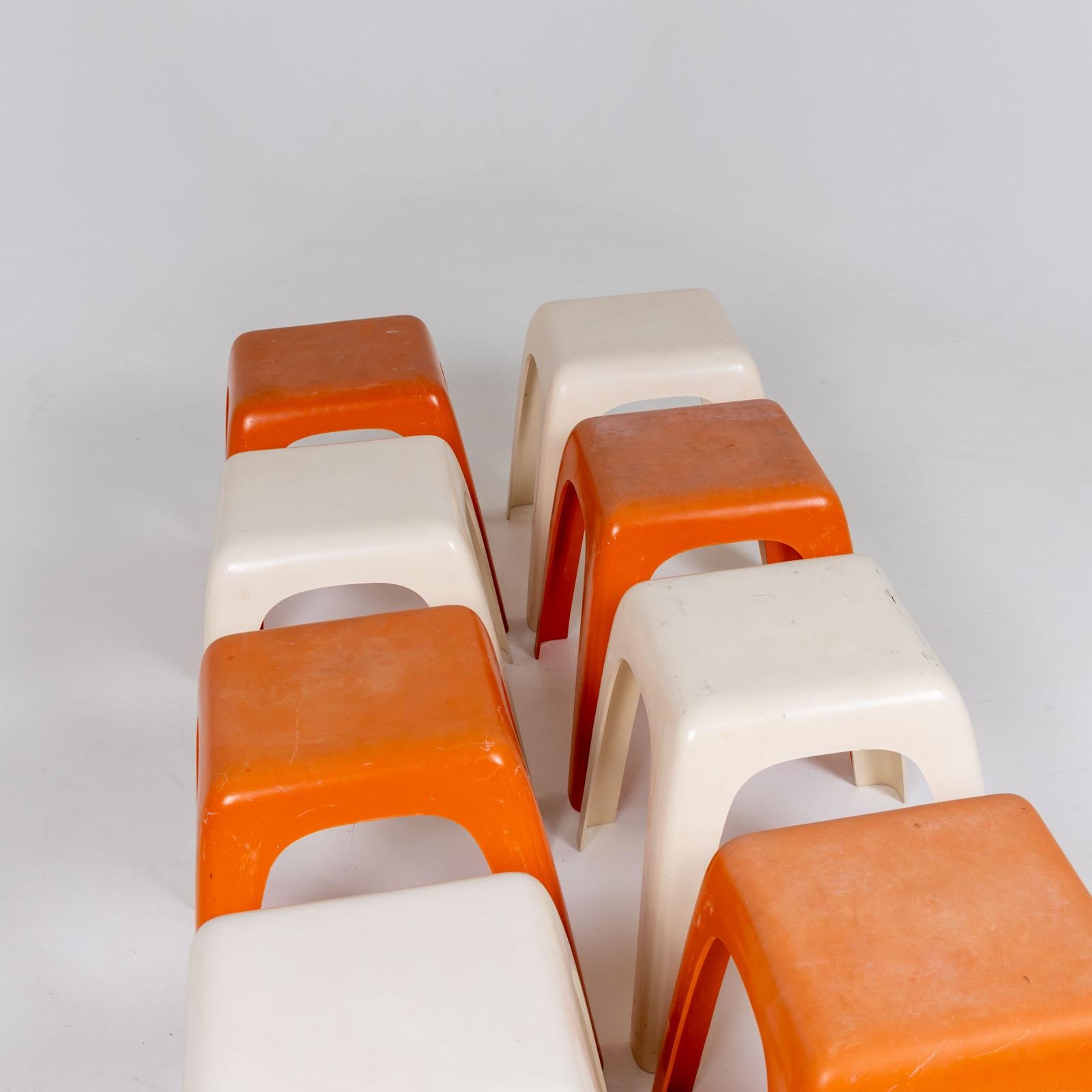 Satz von acht Kunststoffhockern, entworfen von G. Castiglioni, G. Gaviraghi und A. Lanza für Valenti Milano in den 1980er Jahren. Vier der Hocker sind weiß und vier sind orange und weisen einige Gebrauchsspuren auf. 