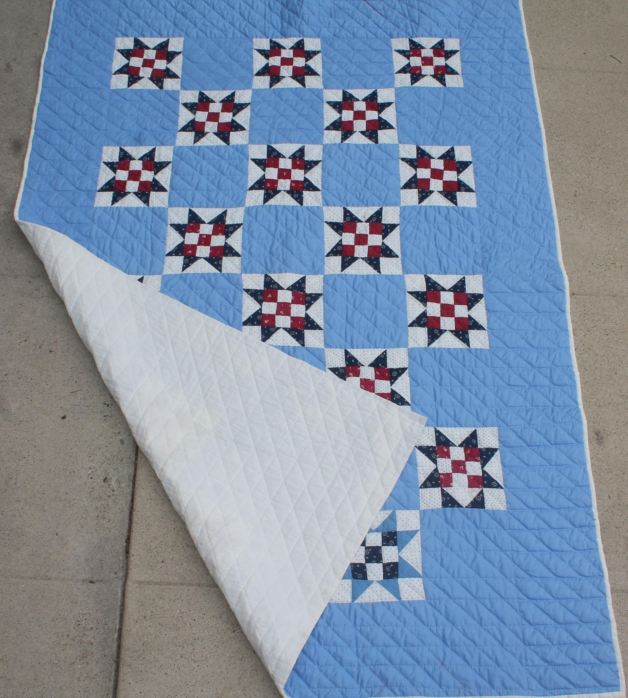 1940s Folky eight point star quilt with a nine patch inside each star. The backing is in a sky blue and all cotton. The condition is very good.