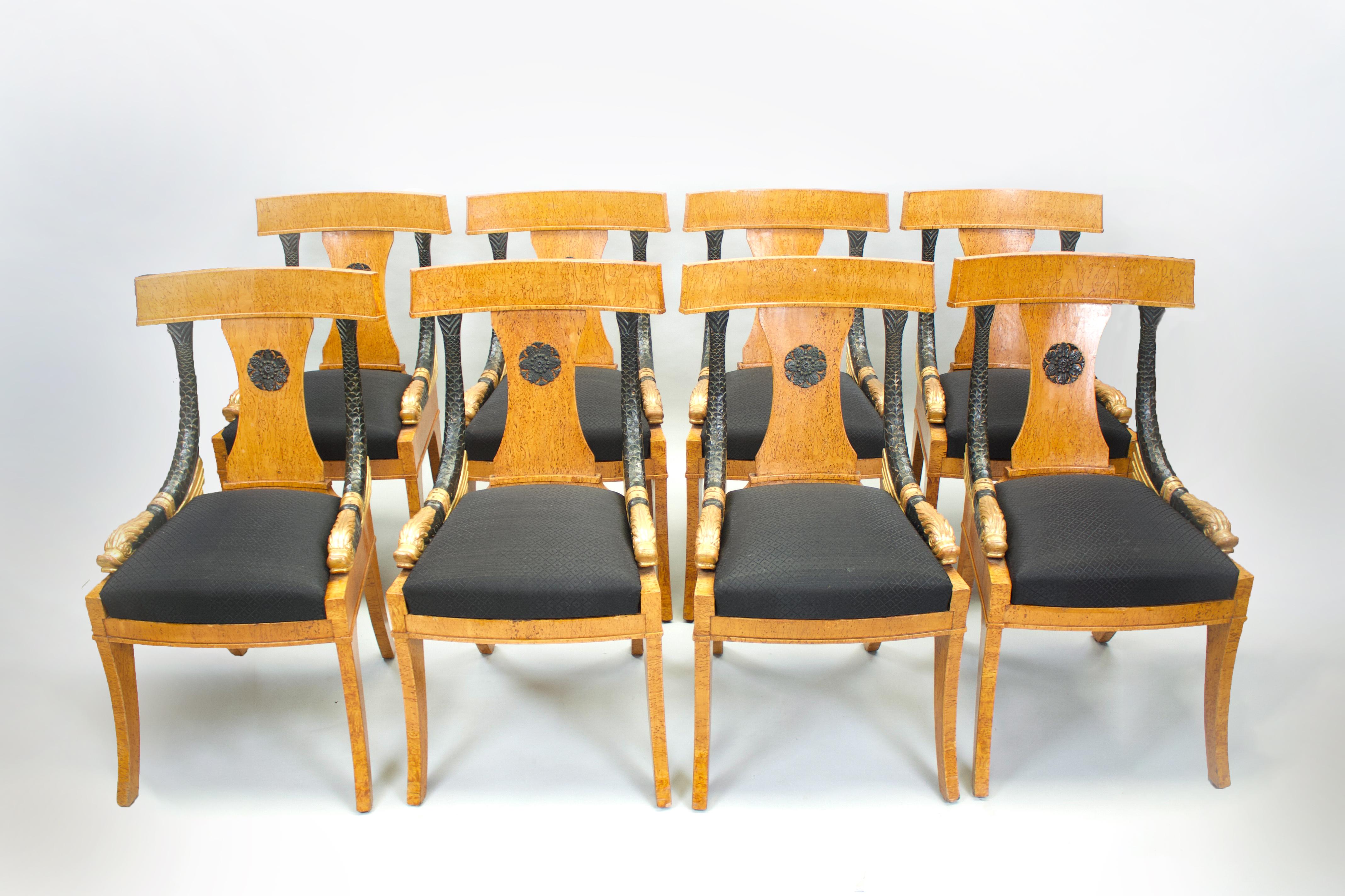 Eight Russian-style dining room chairs in burr veneer and carved wood with dolphin motifs. Armrests in blackened and gilded wood. Upholstered in black fabric.

Dimensions
H 93cm (37”) / L 50cm (20”) / D 50 (20”)
