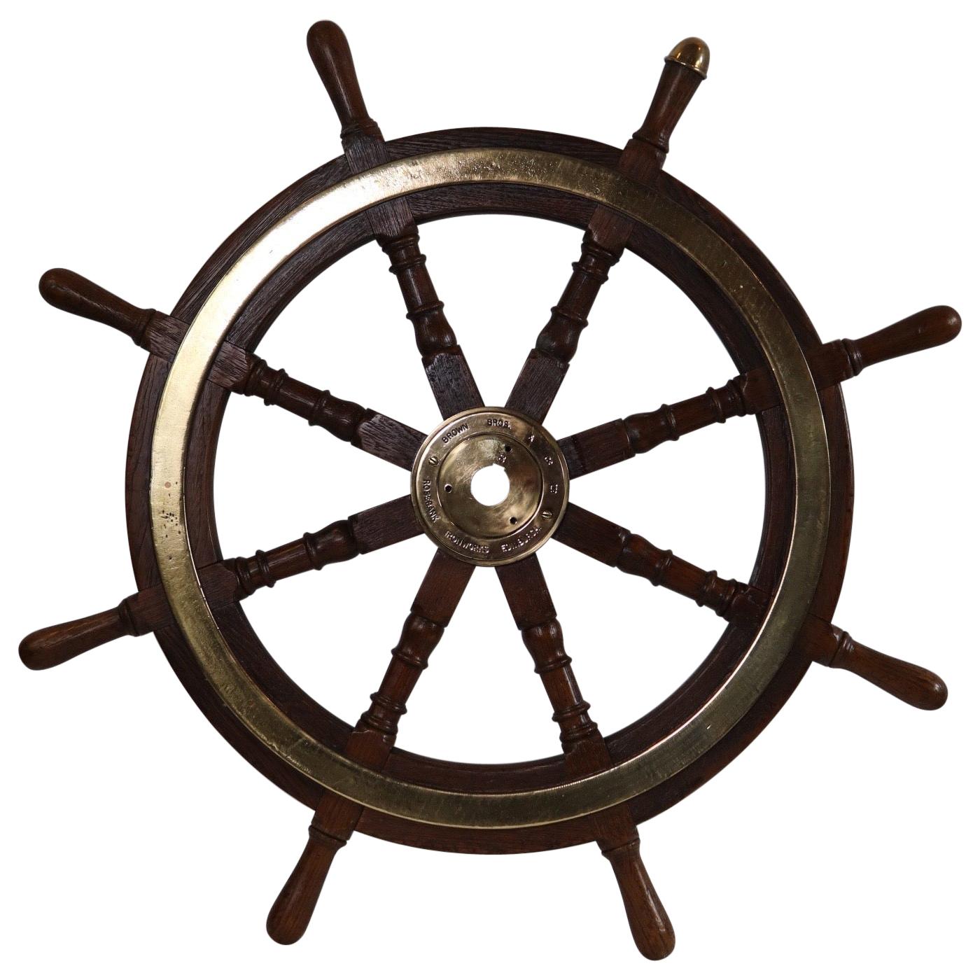 Eight spoke varnished ship's wheel with solid brass hub. Hub is engraved with makers name Brown Brothers and Company, Rosebank Ironworks, Edinburgh. Weight is 36 pounds. 35 Inch Diameter.