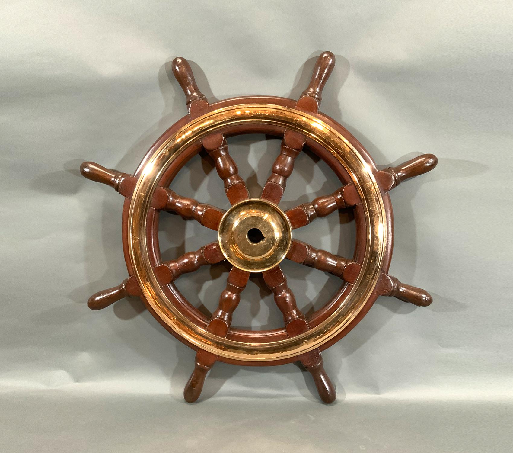 Eight spoke ships wheel with solid brass – Lannan Gallery with brass hub and trim ring. Eight turned posts are fitted to a heavy outer ring with thick inlaid brass band and hub. Varnished finish. 

Weight: 21 LBS
Overall Dimensions: 30