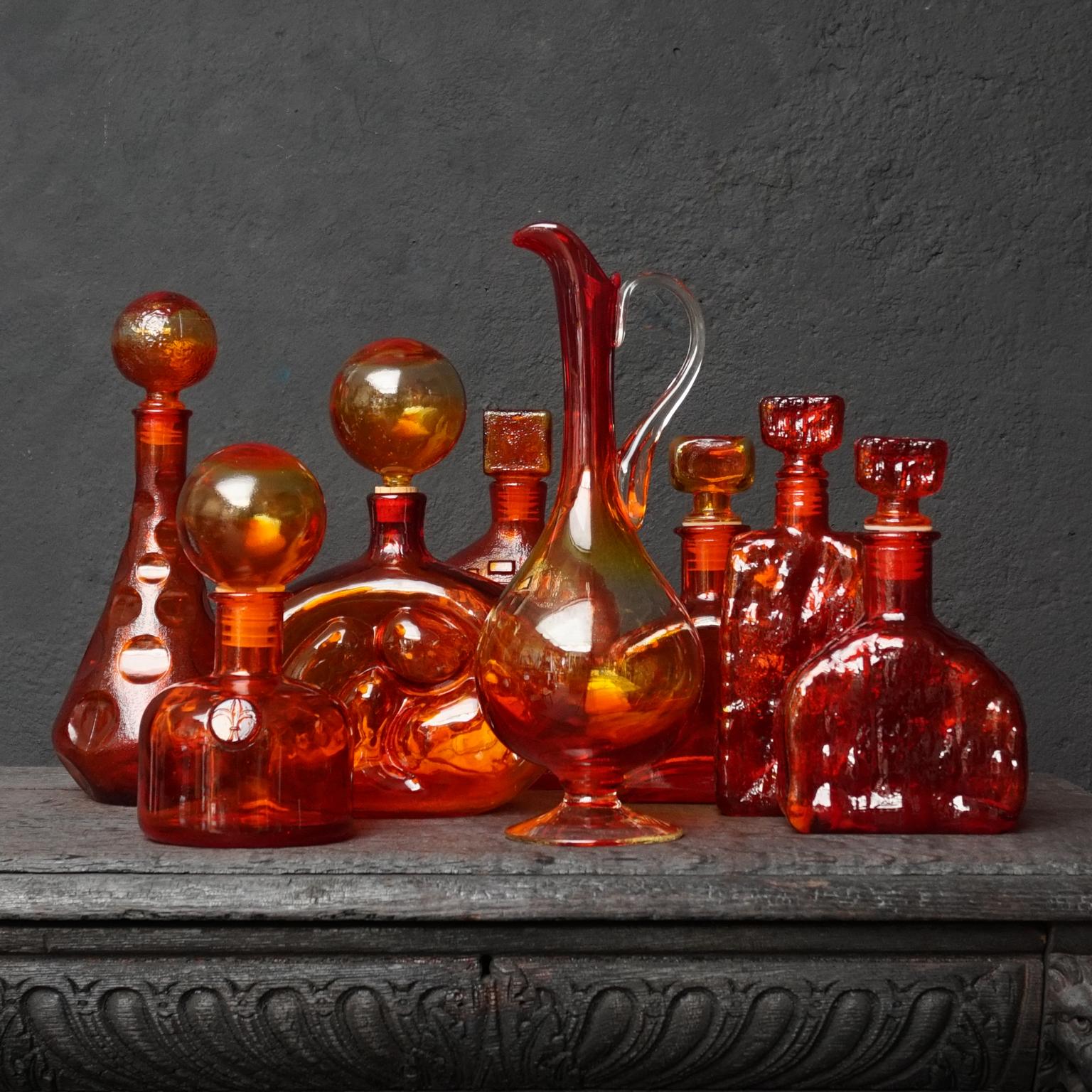 Very pretty set of eight 1960s Italian Empoli Rossini glass decanters in the ever-popular colour Tangerine Amberina, a mixture of ruby red and tangerine orange. In different shapes and styles.
Some compare these colours to those of a brilliant