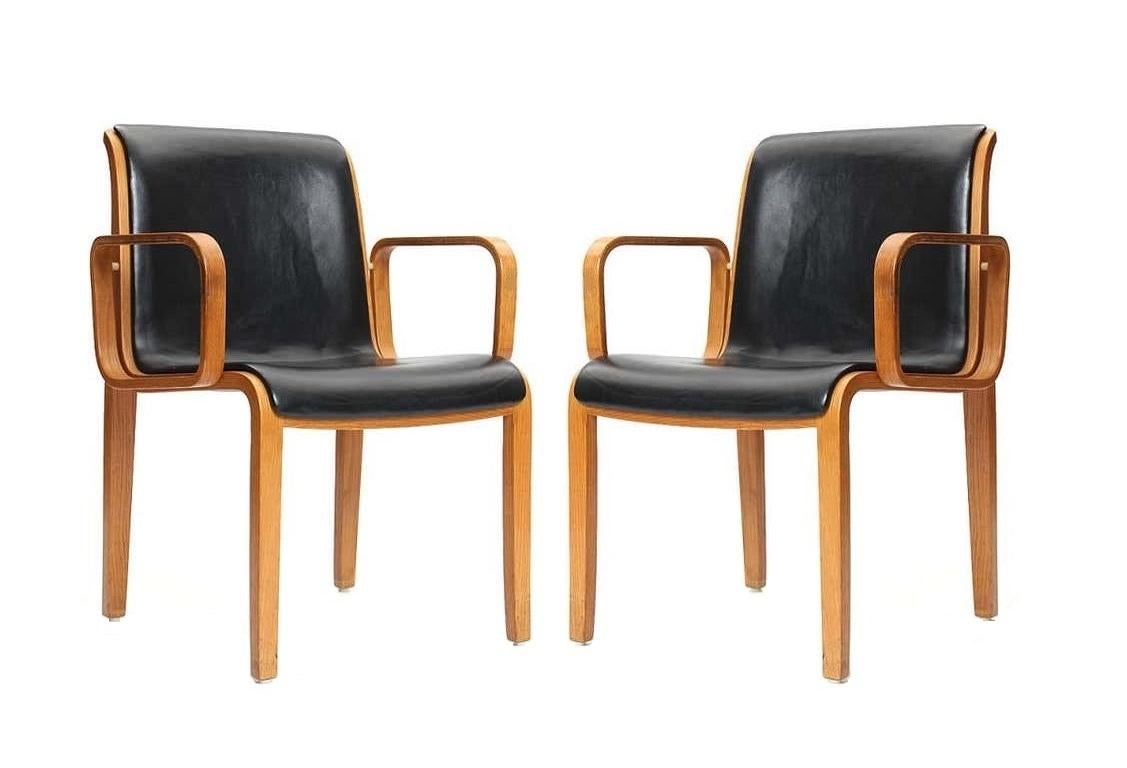 This vintage set of 1300 Series armchairs designed by William 'Bill' Stephens for Knoll. The unique style of Stephens feature gorgeous bent wood with a natural color stain, paired with black upholstery. Marked to underside of frame.