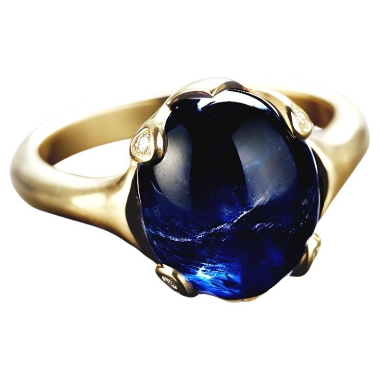 This contemporary ring is crafted in 18 karat white gold and features a beautiful natural dark blue cabochon sapphire, weighing 3.56 carats with 4 small diamonds. We use top-quality natural diamonds from a German gems company that has been in the