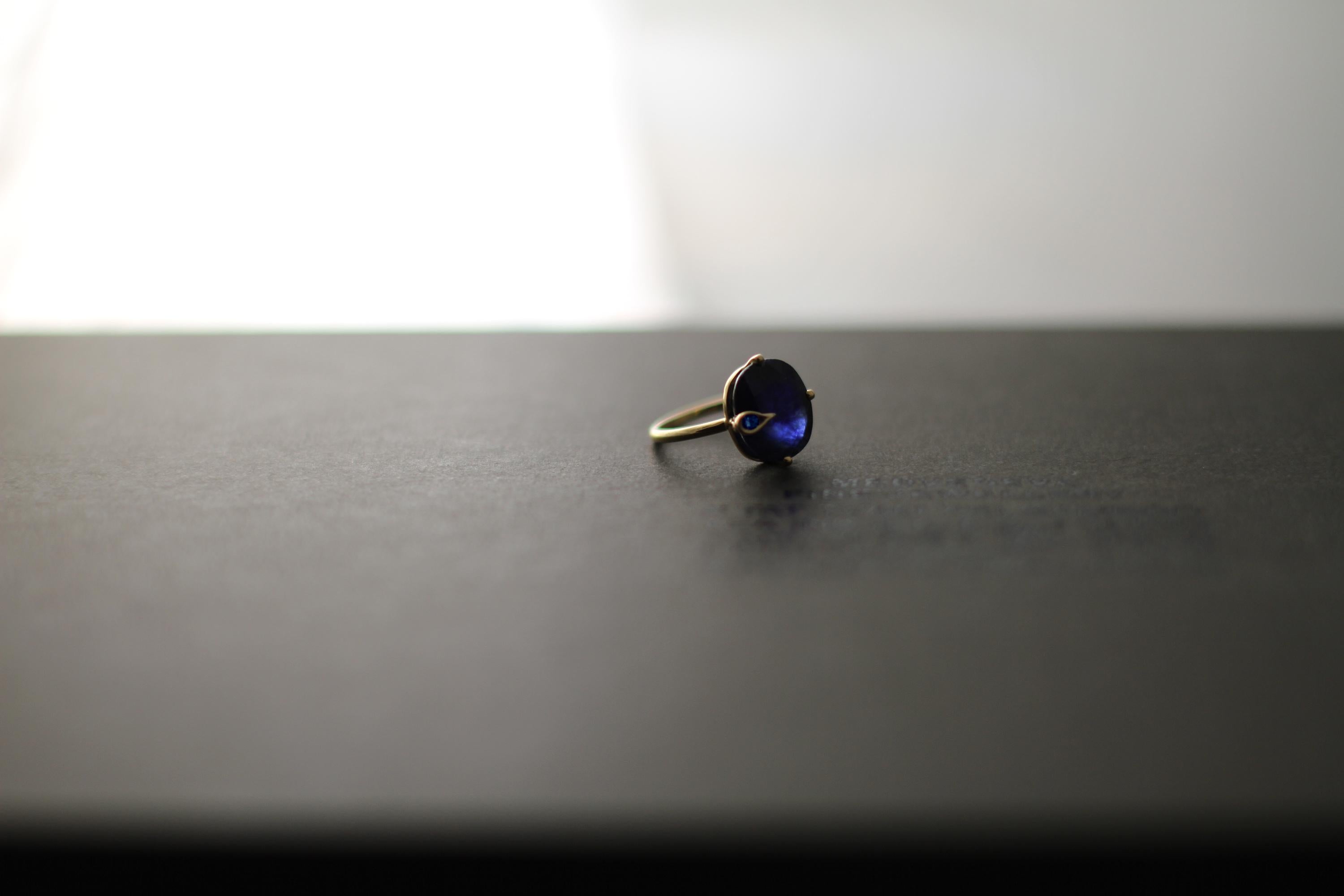 This contemporary Peacock ring is in 18 karat yellow gold with unheated natural cushion cut blue sapphire, 2,55 carats, 0,35x0,3 inches / 9x7,8 mm, and small round sapphire. The ring is easy to wear, and the gem catches eye's attention. 
The