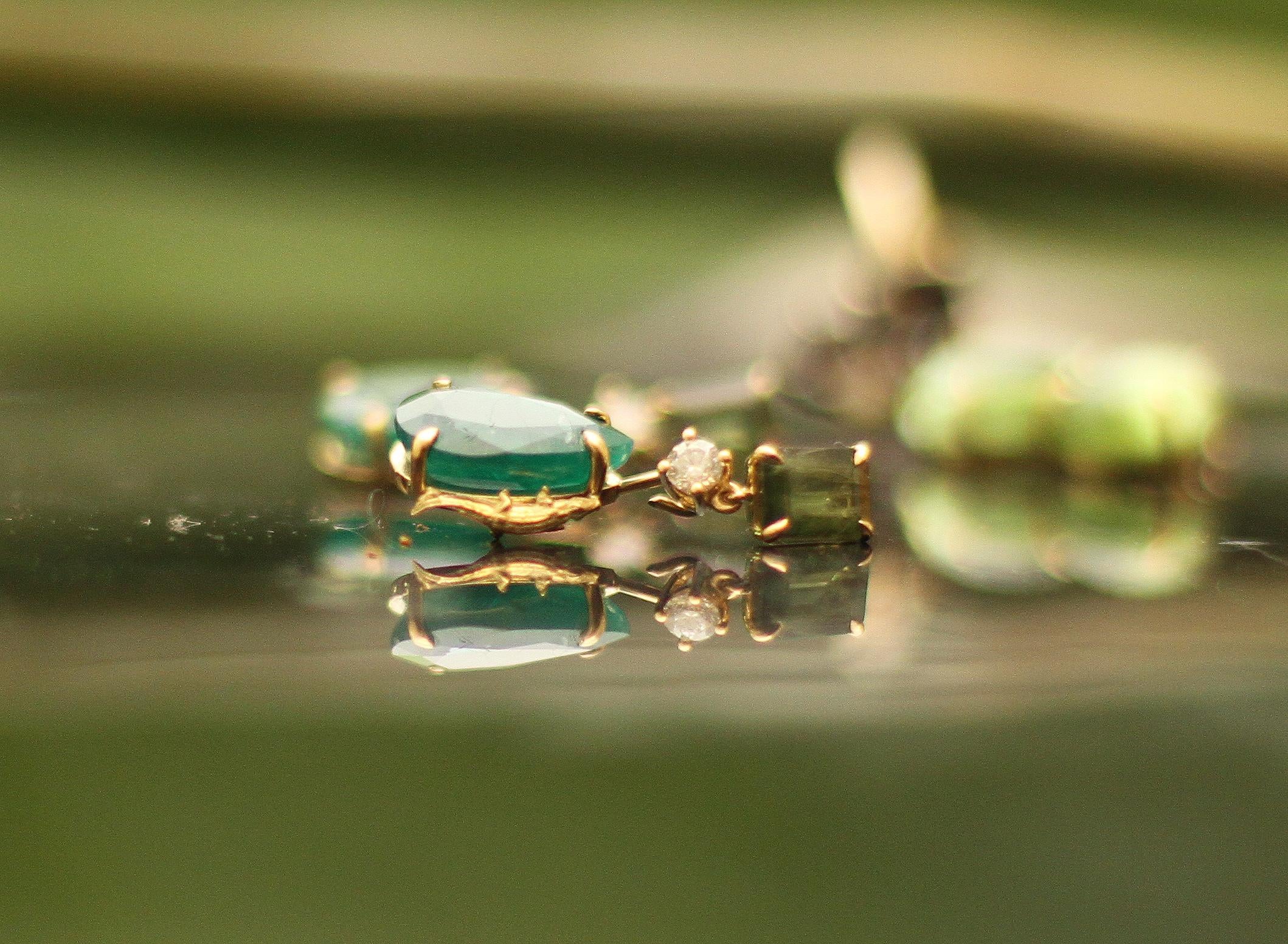 These contemporary stud drop earrings are made of 18 karat yellow gold with cabochon peridots and topazes. We work with german gems company, that is in the market since the 19th century. It has a crocodile detail on the side of one gem.

The