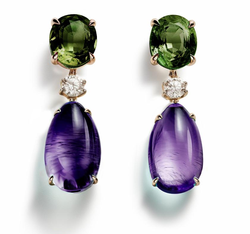These contemporary stud drop earrings are made of 18 karat yellow gold with natural green sapphires (oval cut), cabochon amethysts and round grey diamonds. We work with german gems company, that is in the market since the 19th century. 

The
