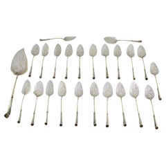 Eighteen silver ice cream scoops and shovel with gilt twists and engravings