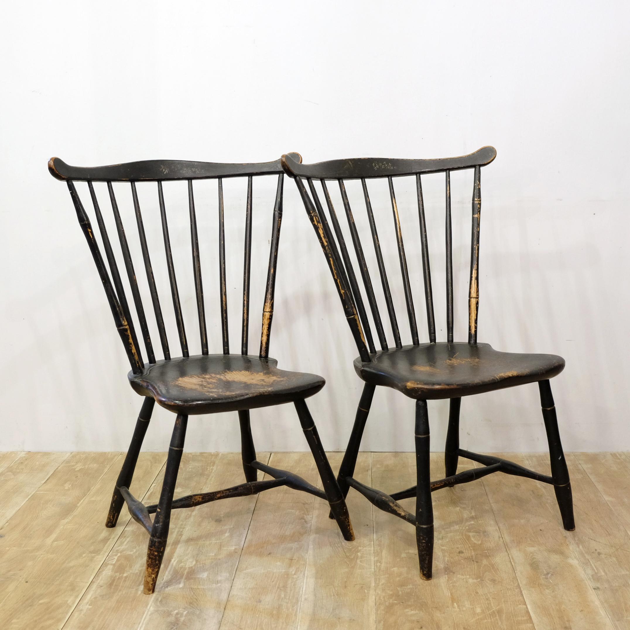 An important near pair of American comb back Windsor chairs in 19th century paint. Likely from the East Connecticut or Rhode Island area of New England, they date to circa 1780. Faux bamboo legs with turned H stretchers supporting shield-shaped