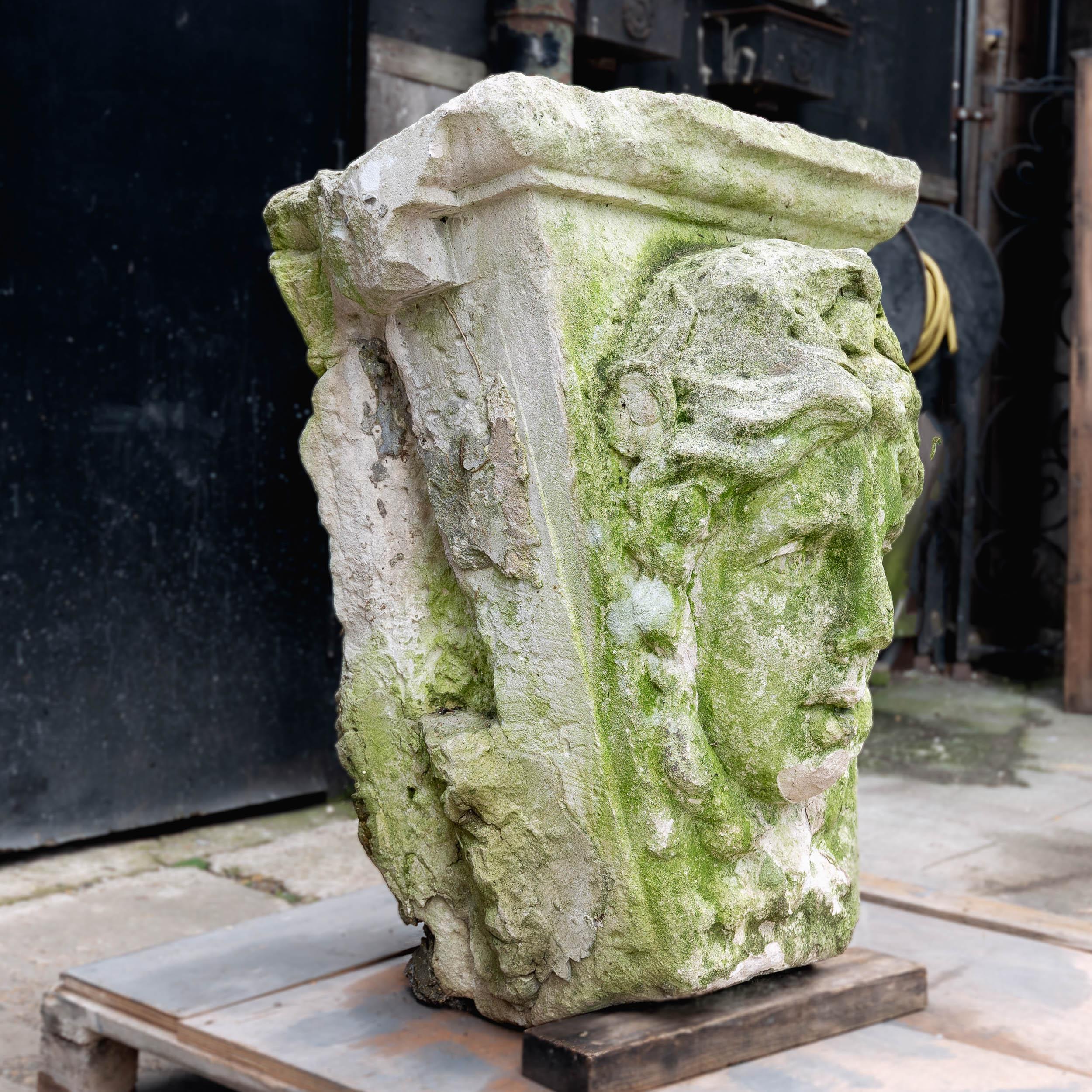 A large carved Portland stone keystone, likely eighteenth century, the tapered form with female mask carved to the front face.