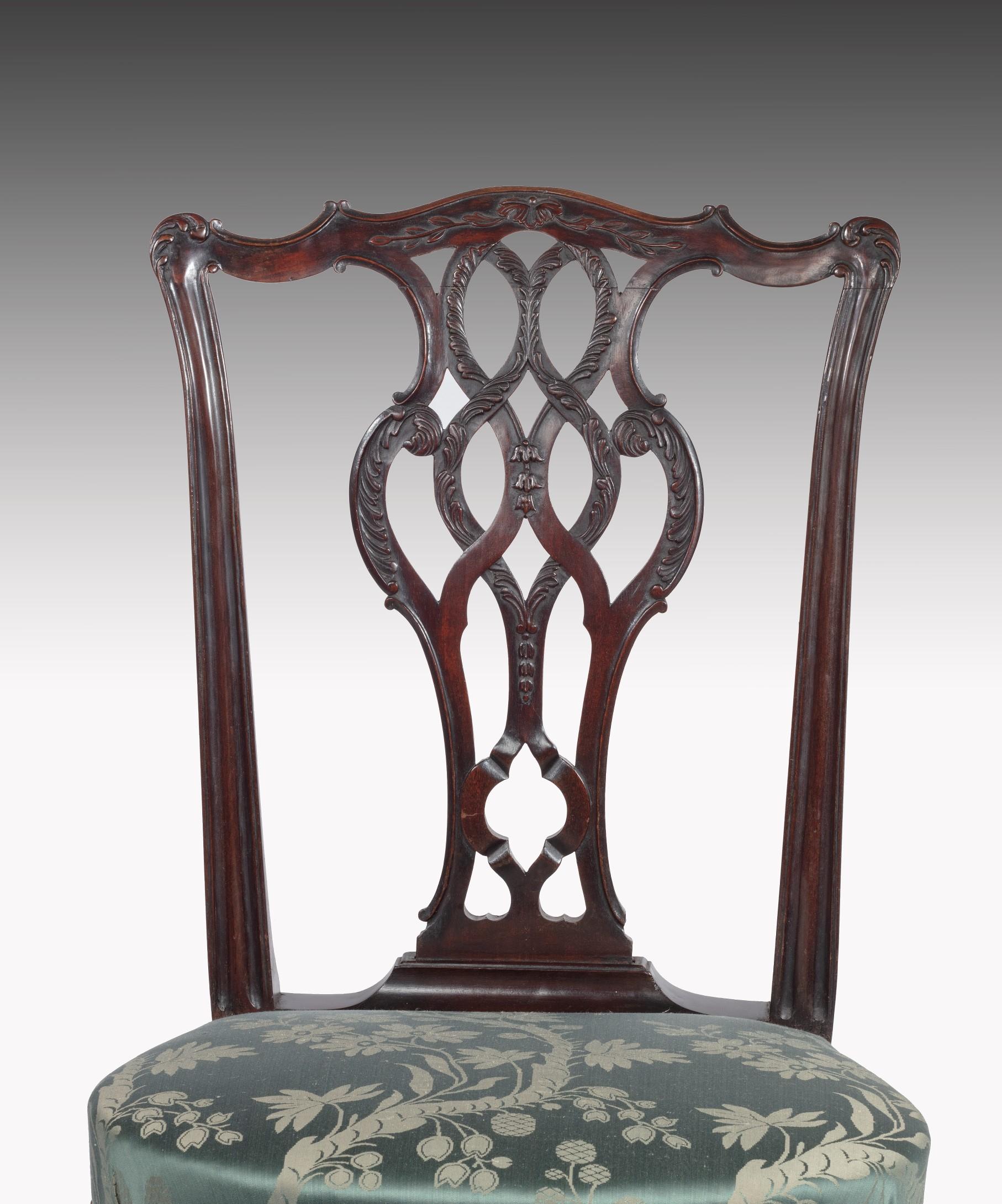 An elegant 18th century George II period carved mahogany side chair; the scrolling top rail above an interlaced splat carved with acanthus leaves and harebells above a stuff over seat upholstered in green damask and raised on cabriole legs which are