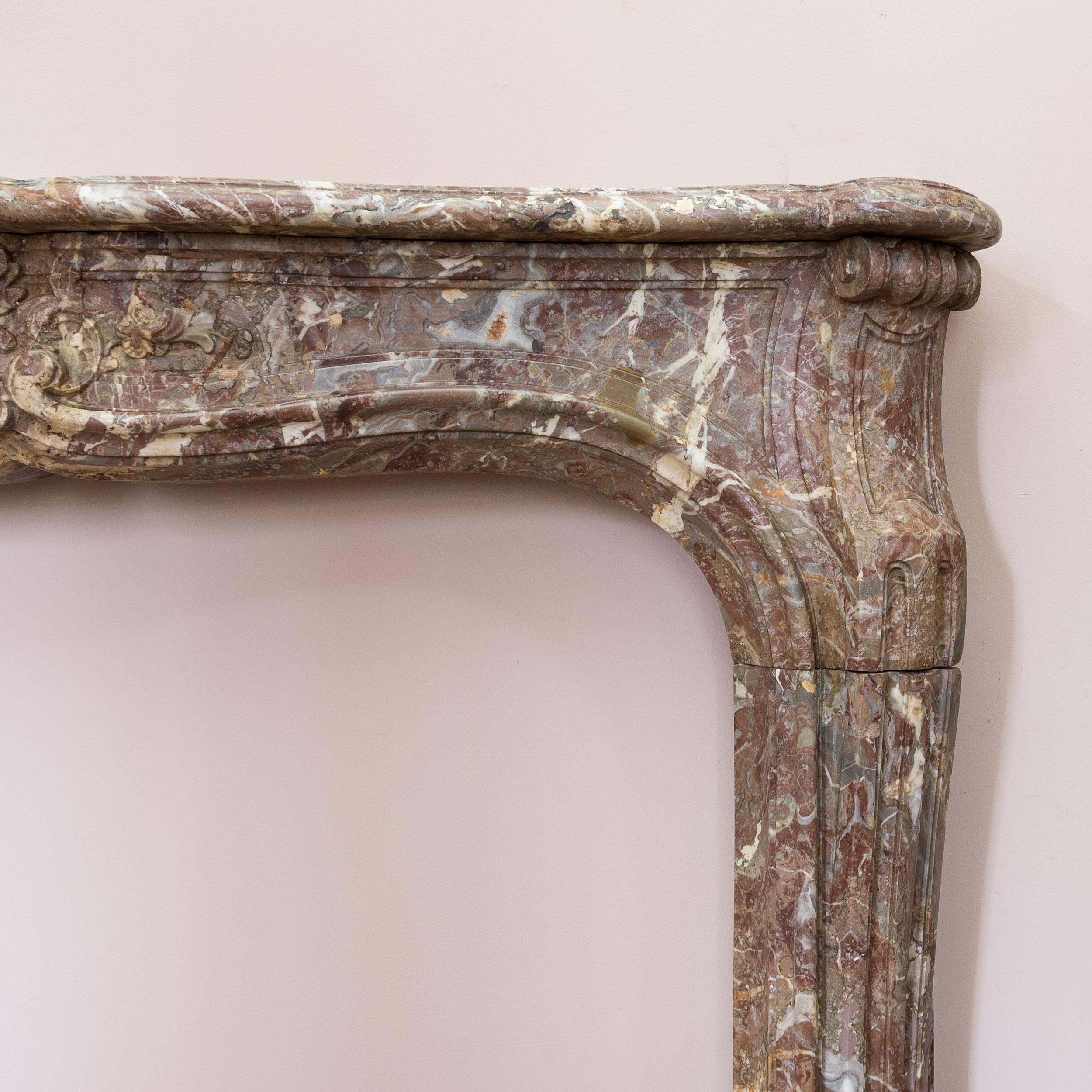 A Louis XV Rouge de Rance marble fireplace, circa 1730-1740, the serpentine moulded shelf above elegant shaped frieze centred by foliate cartouche, the canted and stop-fluted jambs on block feet.

Opening width 128 cm x 90.5 cm high (at centre),