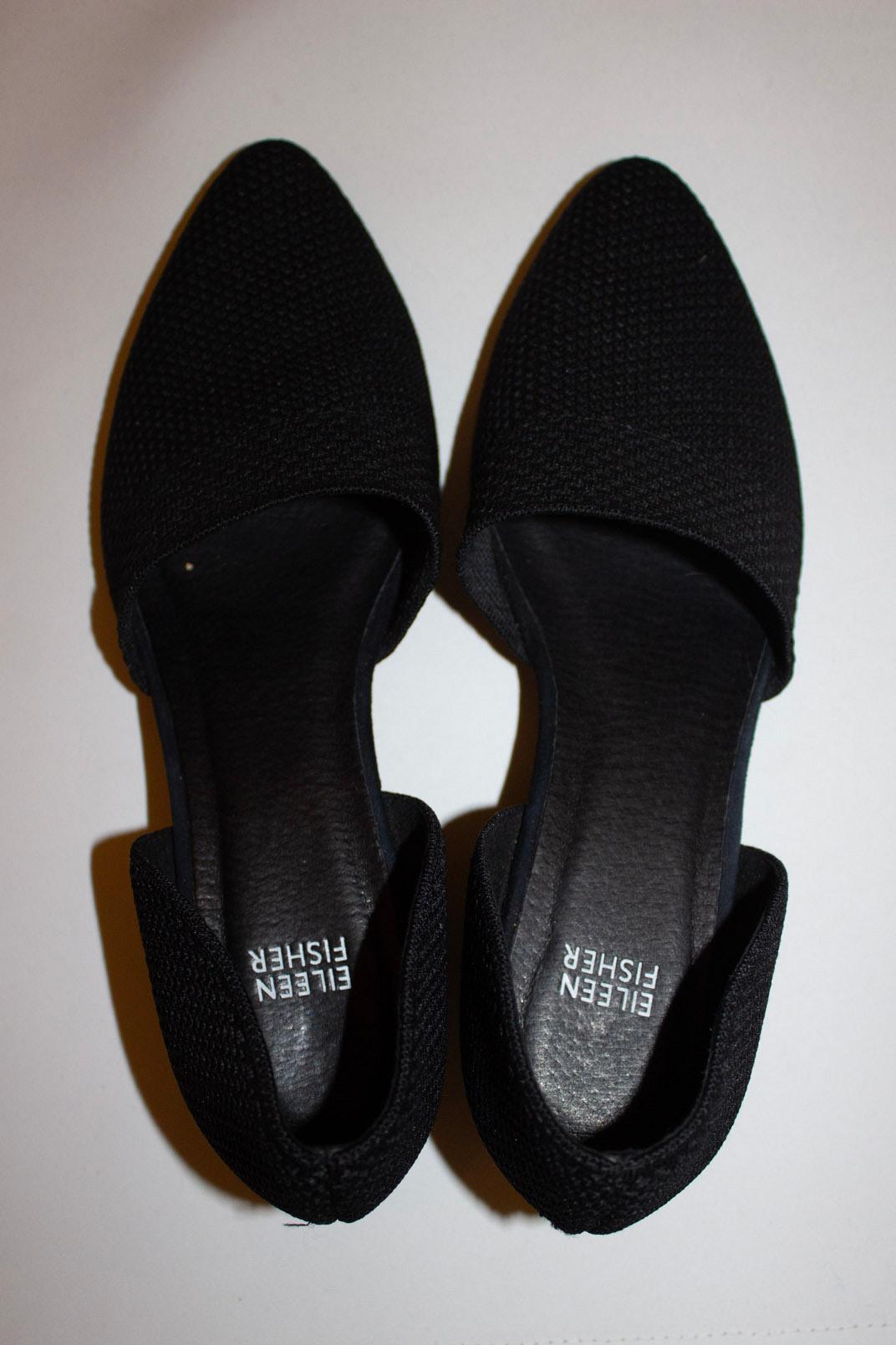 A stylish pair of shoes by Eileen Fisher . They have a black fabric upper , leather sole and intersting long heel. Size US 10 Heel height 2''