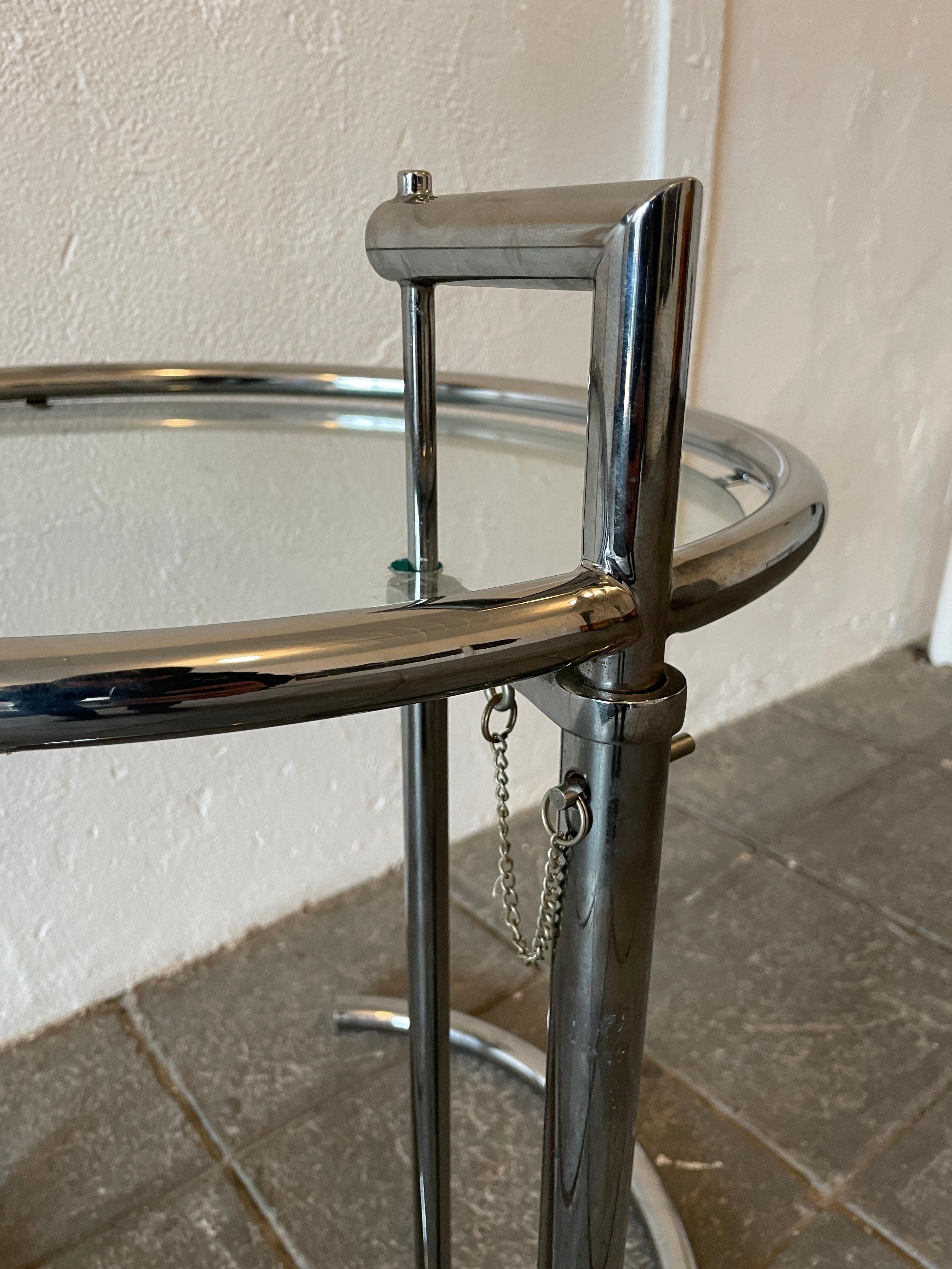 Eileen gray adjustable side table Chrome and glass. Height is adjustable - chrome and clear glass. Located in NYC.