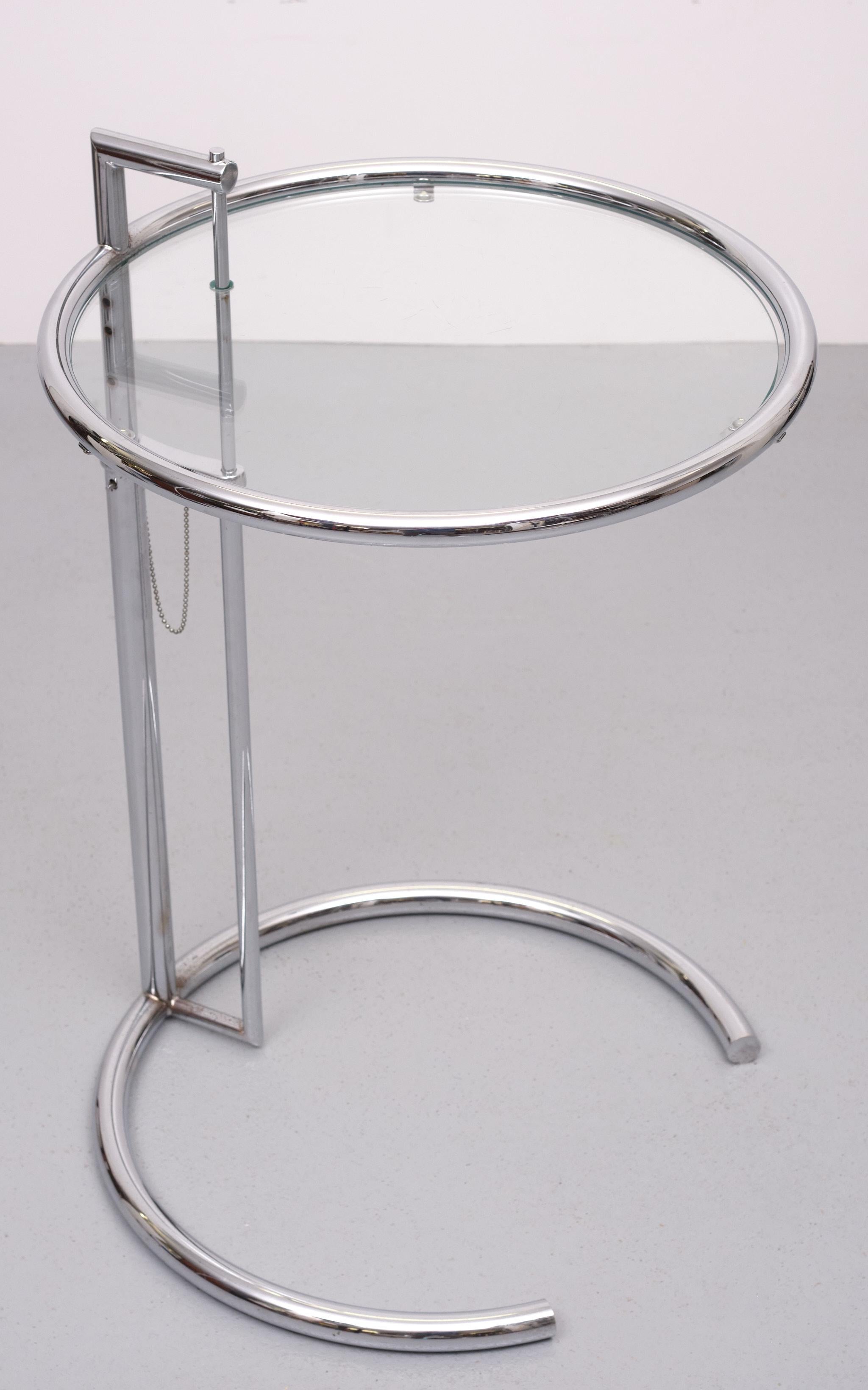 The elegant adjustable table by Eileen Gray stands out formally with its distinctive shape, while its height adjustability makes it not just aesthetically pleasing but functional perfect as a side table. With its clean lines and formal reduction the