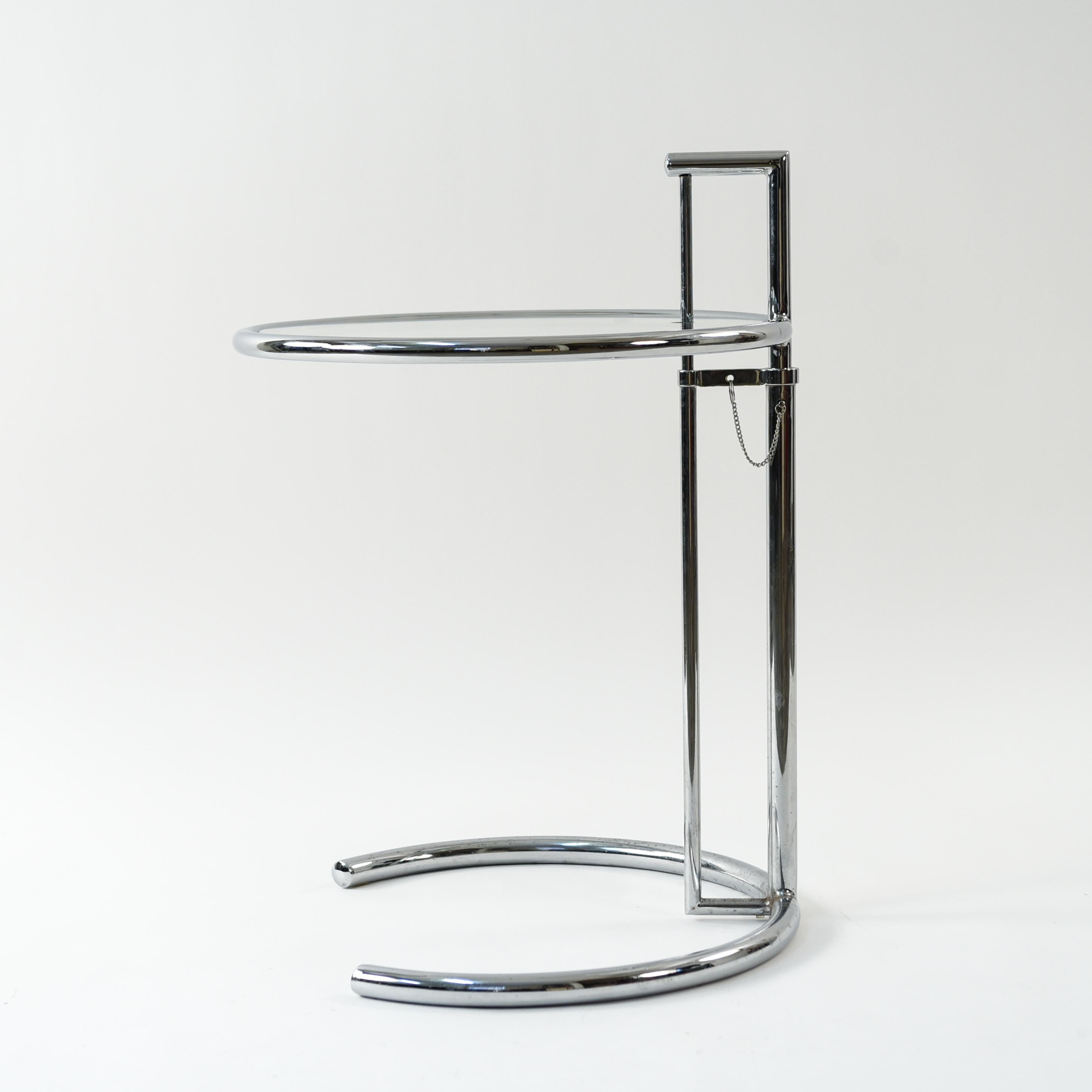 Model E1027 side table designed by Eileen Gray and produced in the 1970s. This piece features tubular chrome plated steel and a replaceable glass top with an iconic adjustable mechanism.