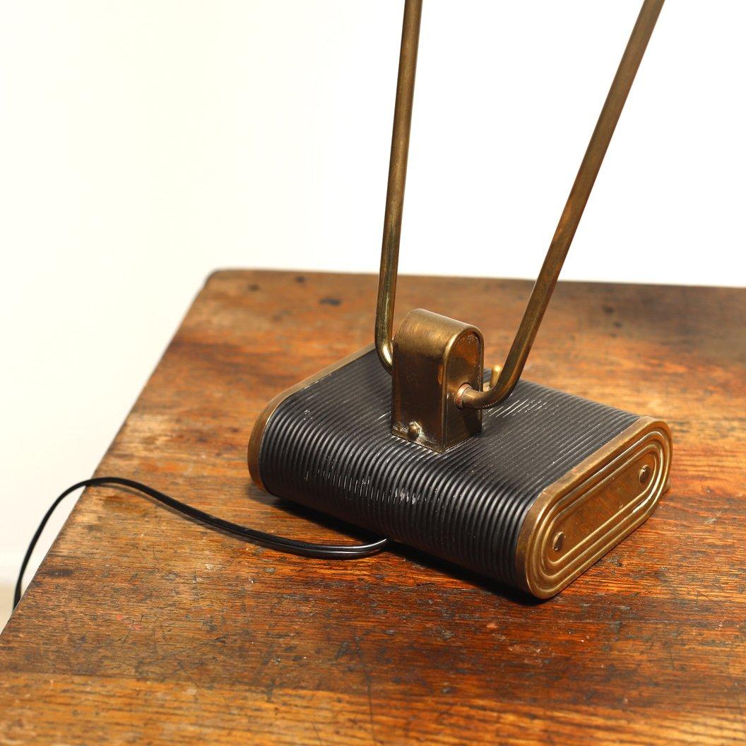 Item No. 27-64

Circa 1940s / France
Size W445 D270 H390 mm
 (base W155 D150mm)

A vintage desk lamp. Designed by Eileen Gray for Jumo in the 1940s. It features a black leatherette covered aluminum sheet and a curved chrome-plated brass tube.