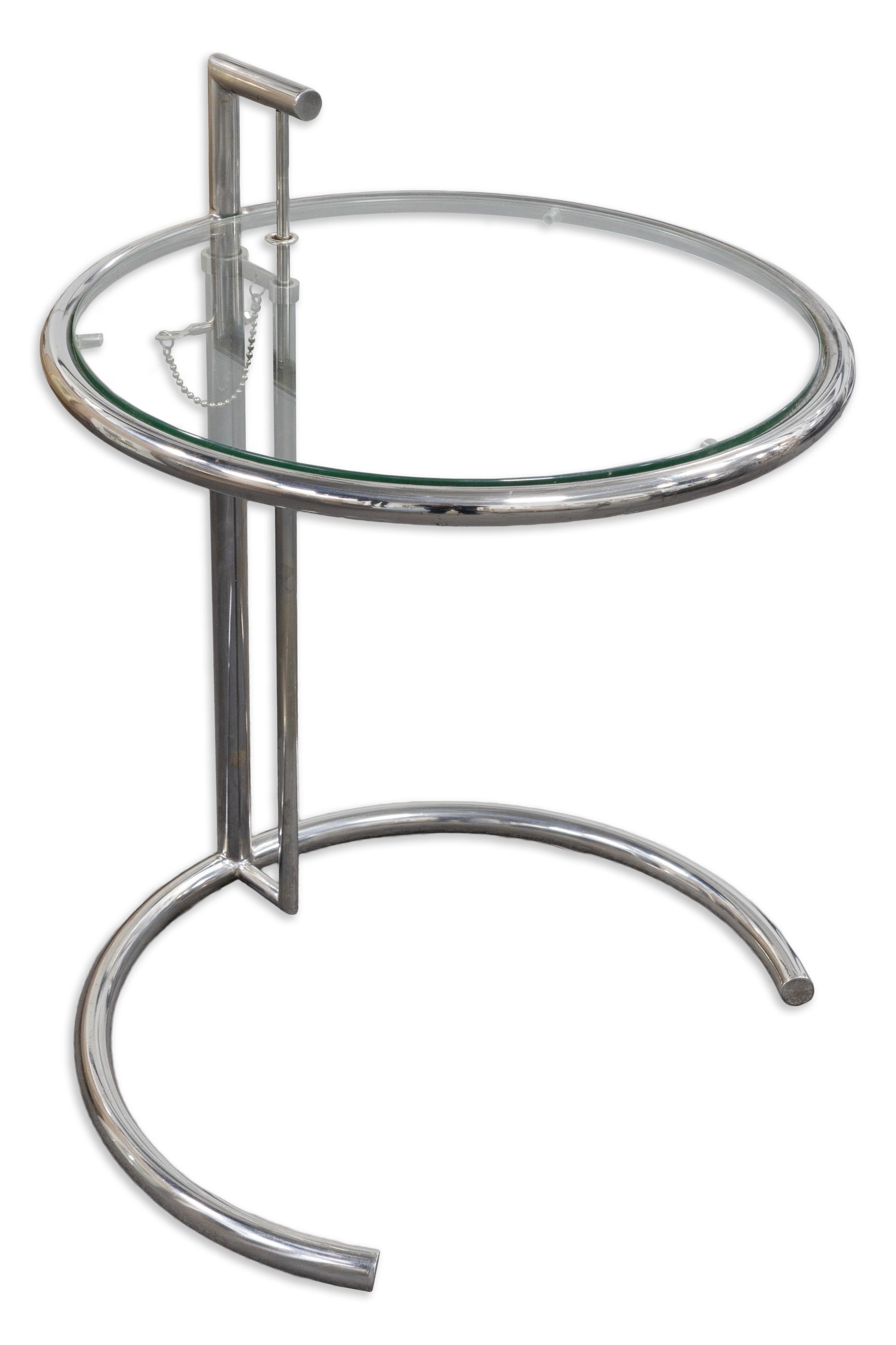 Dieser verstellbare Beistelltisch im Stil von Eileen Gray ist ein Designklassiker mit einem schlanken Chromrohrgestell und einer runden Glasplatte. Der Tisch wurde mit Blick auf Eleganz und Vielseitigkeit entworfen und kann mit dem