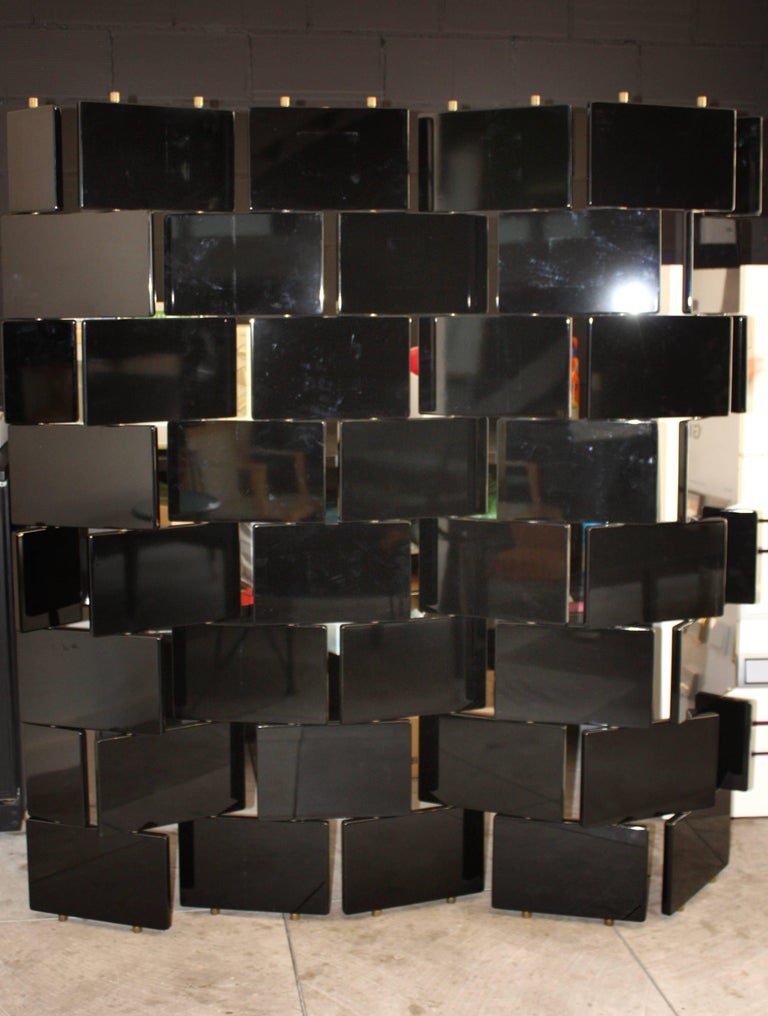 Eileen Gray style folding screen or room divider, made in black lacquered wood moveable panels and brass structure.