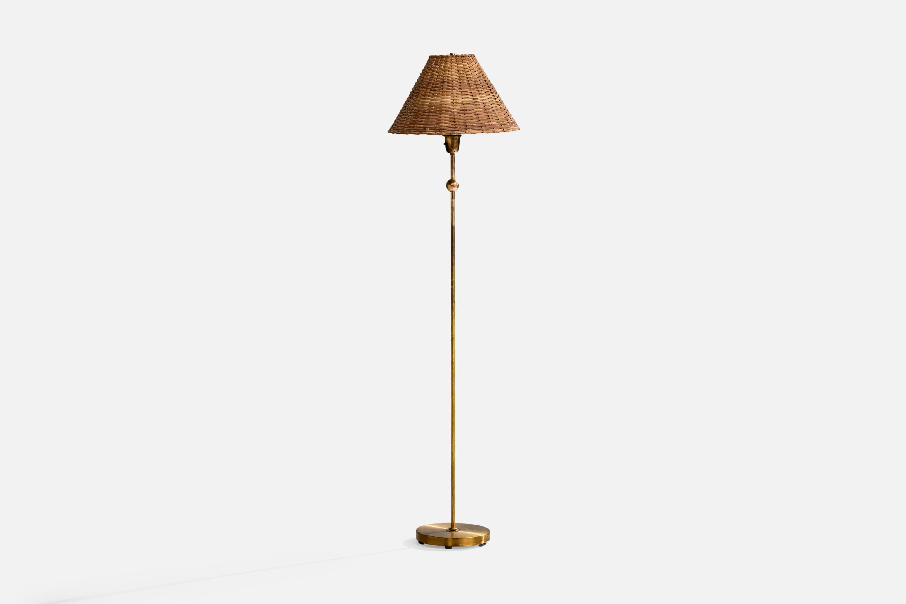 A brass and rattan floor lamp designed and produced by Einar Bäckström, Sweden, 1950s.

Overall Dimensions (inches): 57