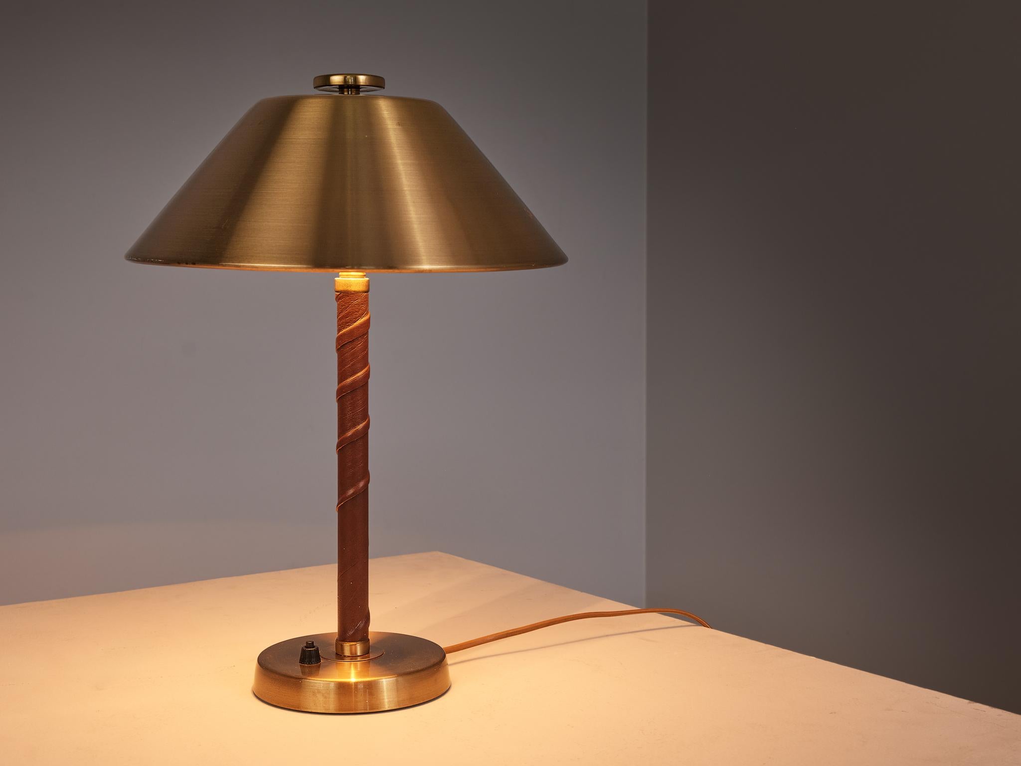 Einar Bäckström, table lamp, model 5014, brushed brass, leather, Sweden, 1940s. 

This table lamp is designed by Swedish designer Einar Bäckström in his workshop in Malmö, which he founded in 1918. This table lamp is a delightfully distinctive model