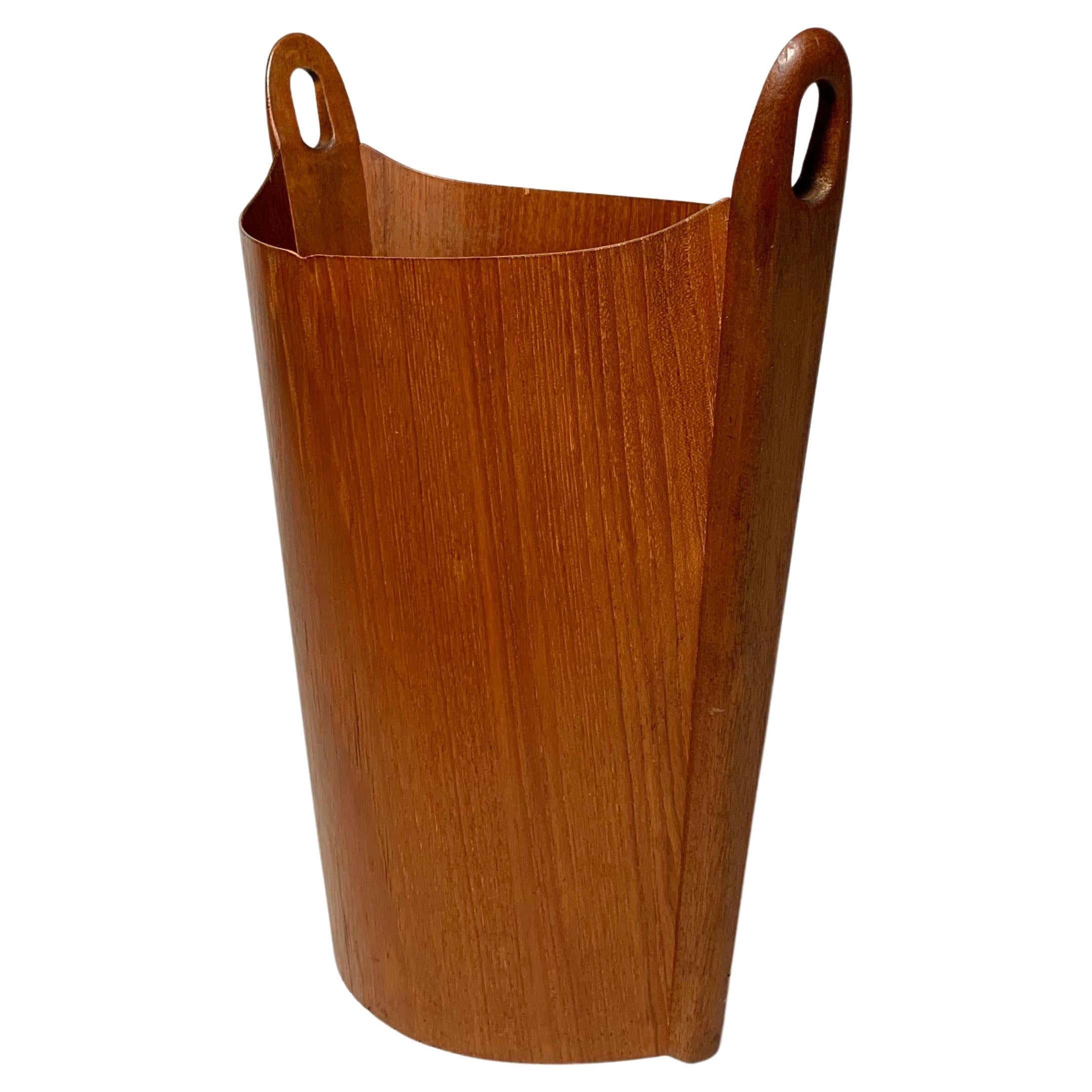 Paper waste basket, model ‚Oval’ designed by Einar Barnes in 1969 and produced by P.S. Heggen in Norway in the 1970s.

Teak plywood with solid teak handles on both sides. Stamped on the inside bottom.

Measures: Height: 44 cm
Width: 38