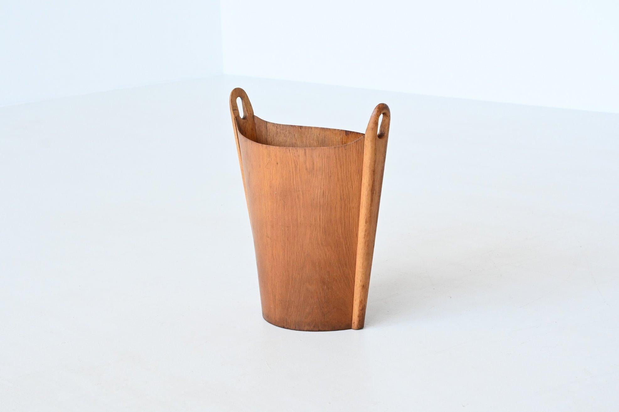 Beautiful elegant shaped waste bin designed by Einar Barnes for P.S. Heggen, Norway 1960. This Danish modern two-tone wastebasket is made of teak and oak wood. The lovely ovoid shape is made of teak plywood sides with solid oak sculptural end pieces