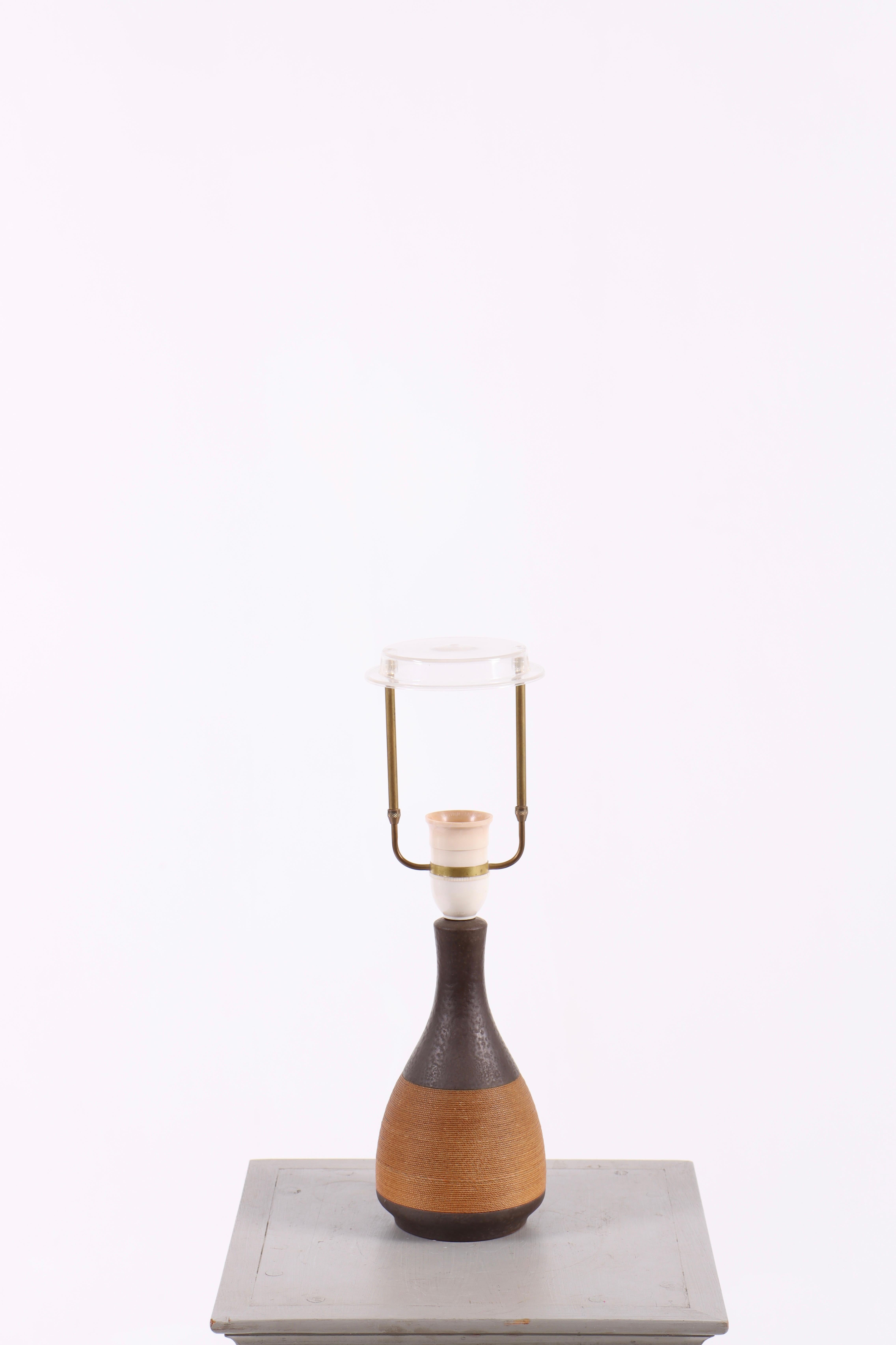 Lampe de table élégante conçue par Einar Johansen au Danemark dans les années 1960. La lampe est fabriquée en céramique avec des détails décoratifs en corde, créant une expression chaleureuse et organique. La combinaison de matériaux naturels lui
