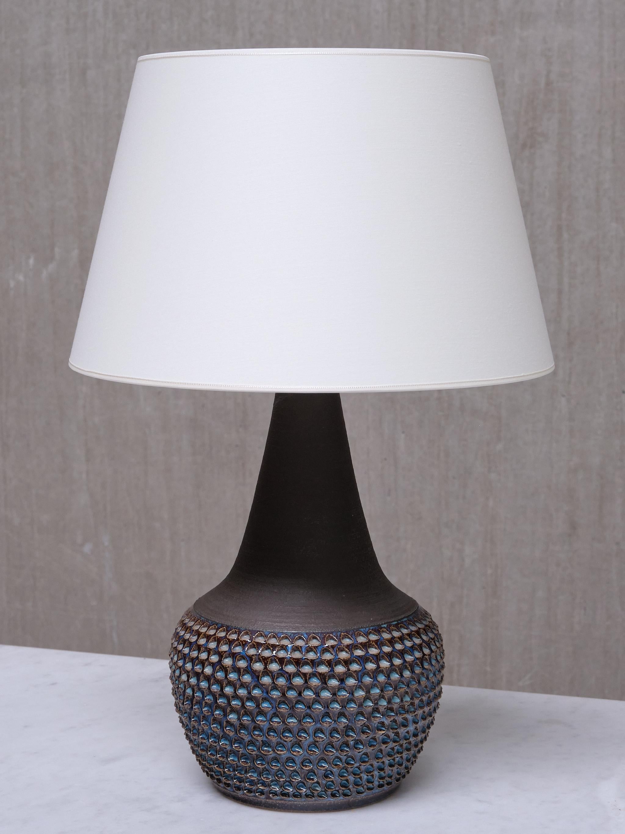 Cette élégante lampe de table a été conçue par Einar Johansen et produite par Søholm Stentøj au Danemark dans les années 1960. La lampe est estampillée avec le nom du fabricant et le numéro de modèle 3048 sur le dessous de la base.

La base en