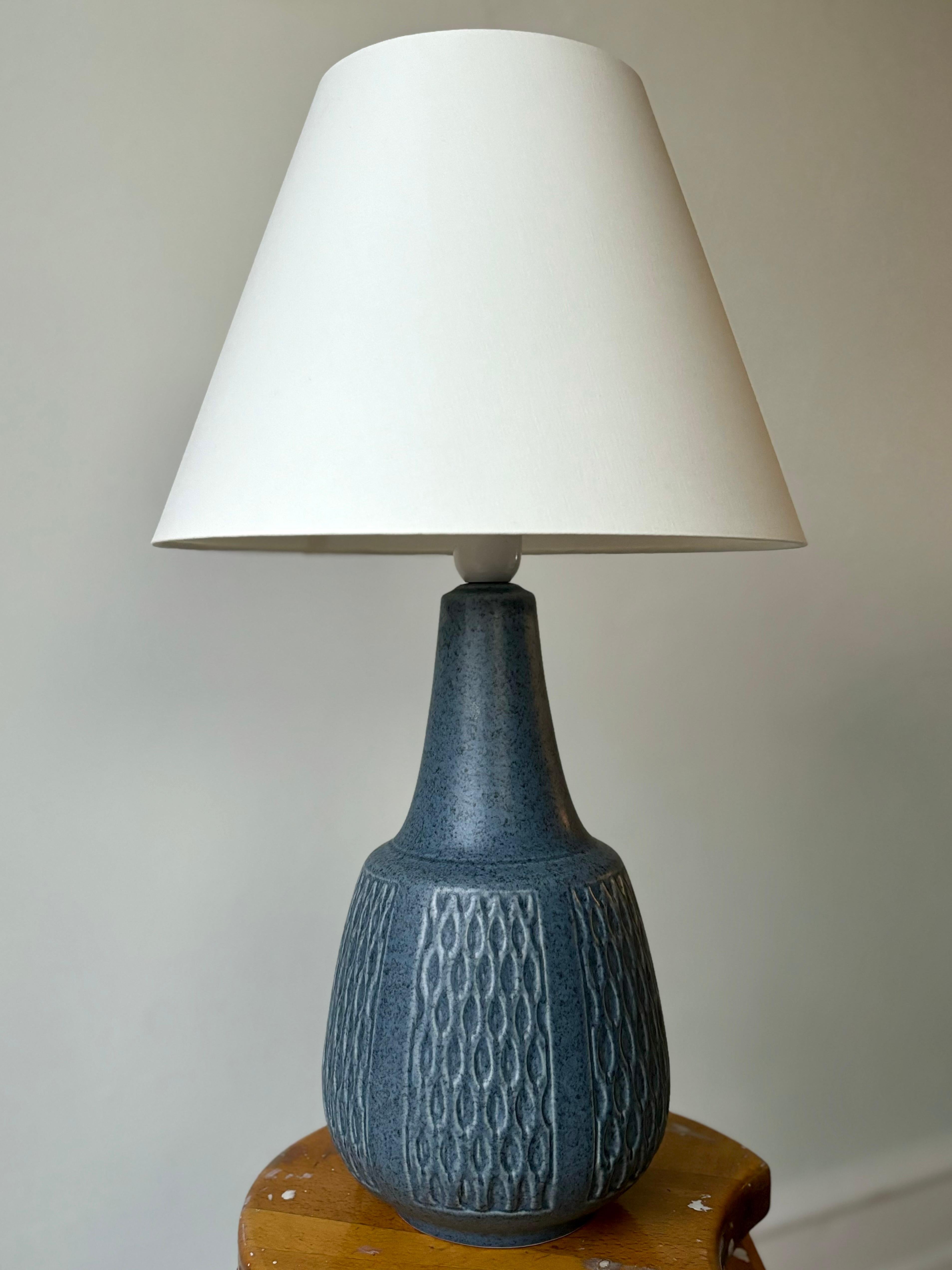 Lampe de table en céramique bleu clair poussiéreuse fabriquée à la main par l'artiste céramiste danois Einar Johansen dans les années 1960. Motif graphique en relief autour de la panse avec glaçure mate mouchetée. Signé et numéroté sous la base.