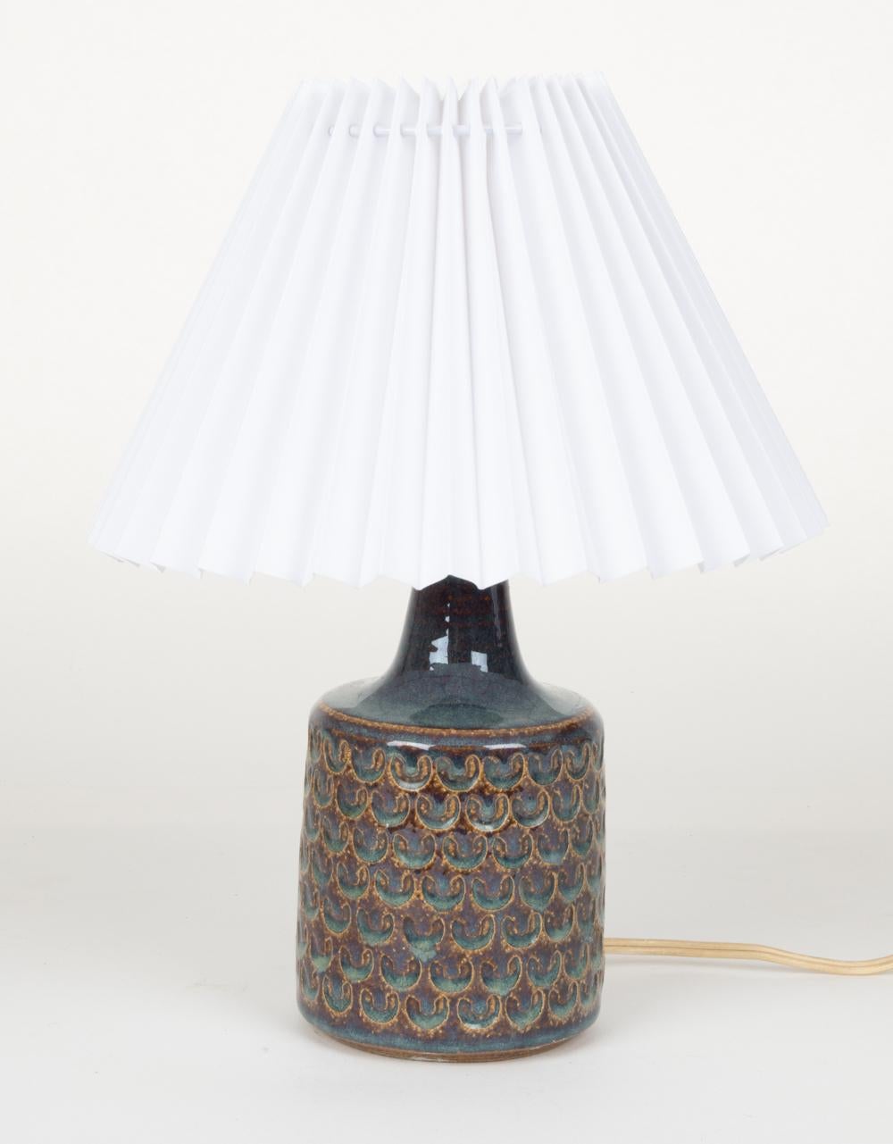 A stylish petite Scandinavian mid-century table lamp with a patterned ceramic surface in stunning mottled turquoise and mustard glaze. Designed by Einar Johansen and produced by Soholm Stentoj, this charming Danish modern lamp is a product of