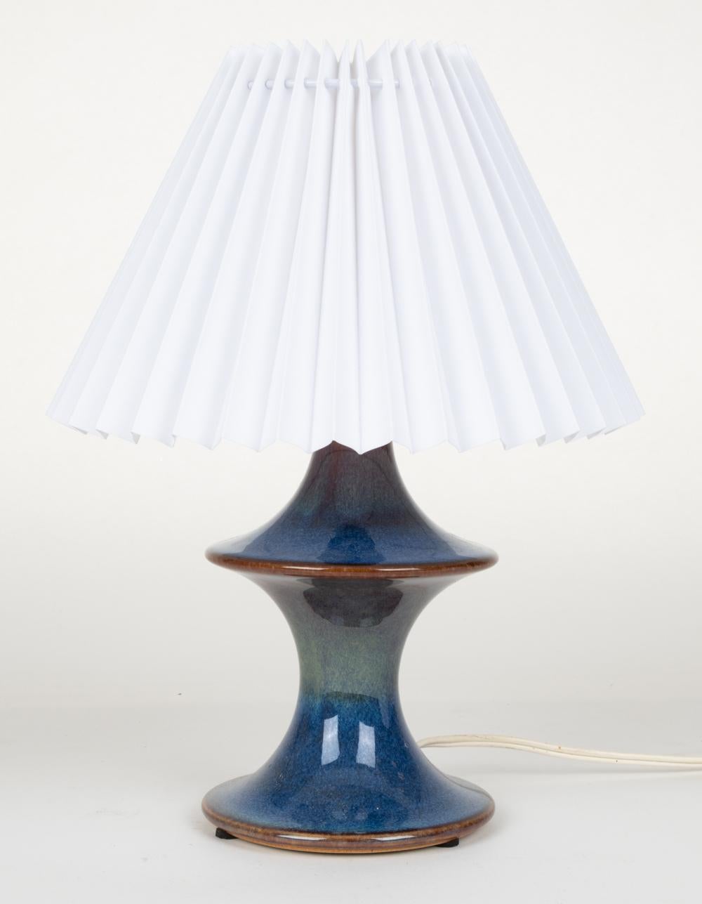A Scandinavian mid-century petite shaped table lamp in ceramic with a glossy mottled blue multi-tone glaze. An unusual and rare form, designed by Einar Johansen for Soholm Stentoj, circa 1960s. Marked underneath. 
Lampshade not included.