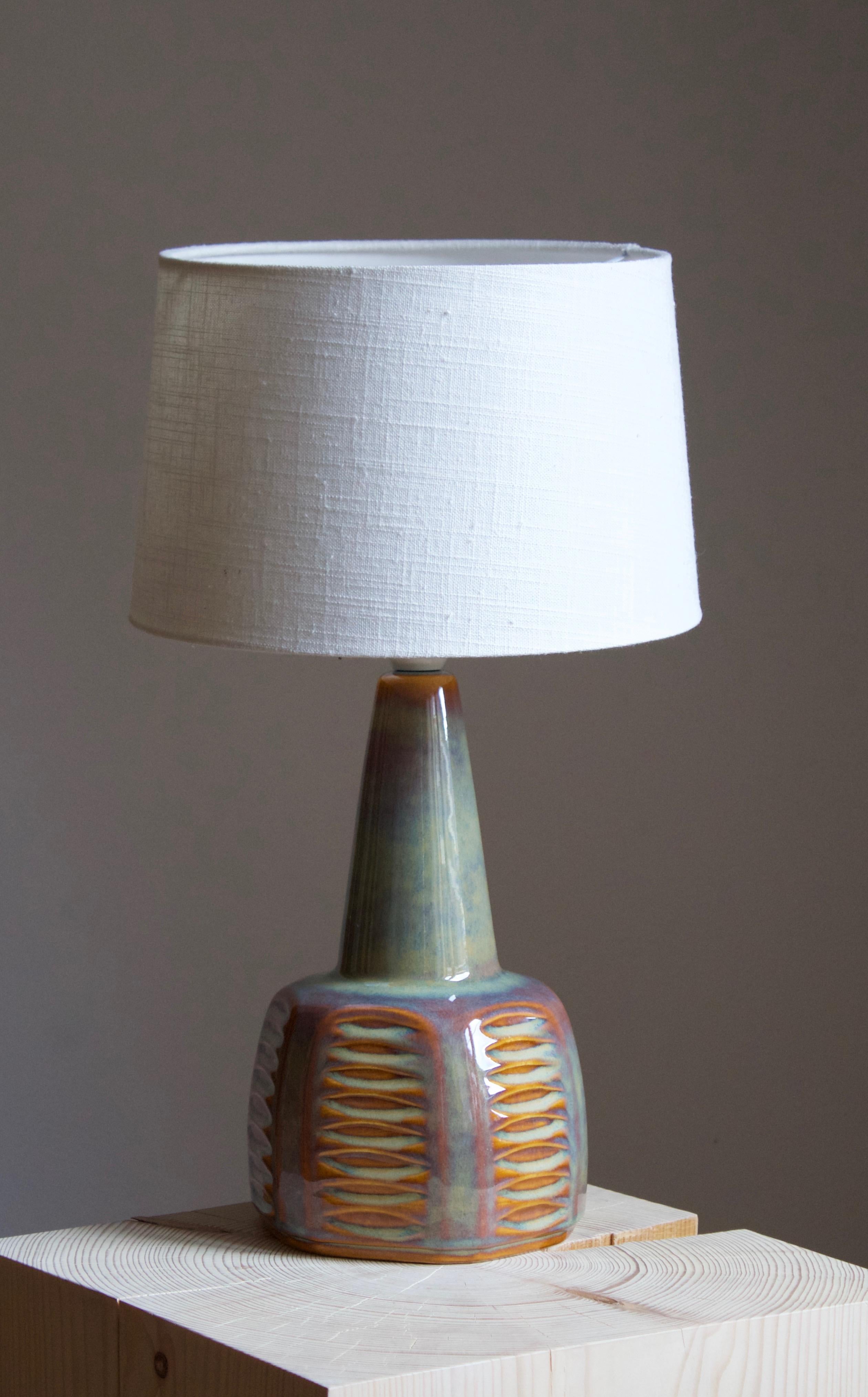 A table lamp produced by Søholm Keramik, located on the island of Bornholm in Denmark. Features a highly artistic glazed and incised decor. 

Sold without lampshade. Stated dimensions exclude the lampshade. Height includes socket.

Glaze features