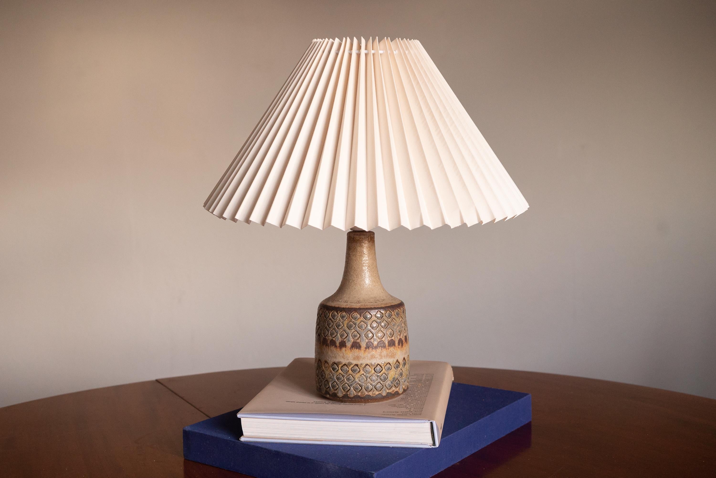 A table lamp produced by Søholm Keramik, located on the island of Bornholm in Denmark. Features a highly artistic glazed and incised decor.

Sold without lampshade. Stated dimensions exclude the lampshade. Height includes socket.