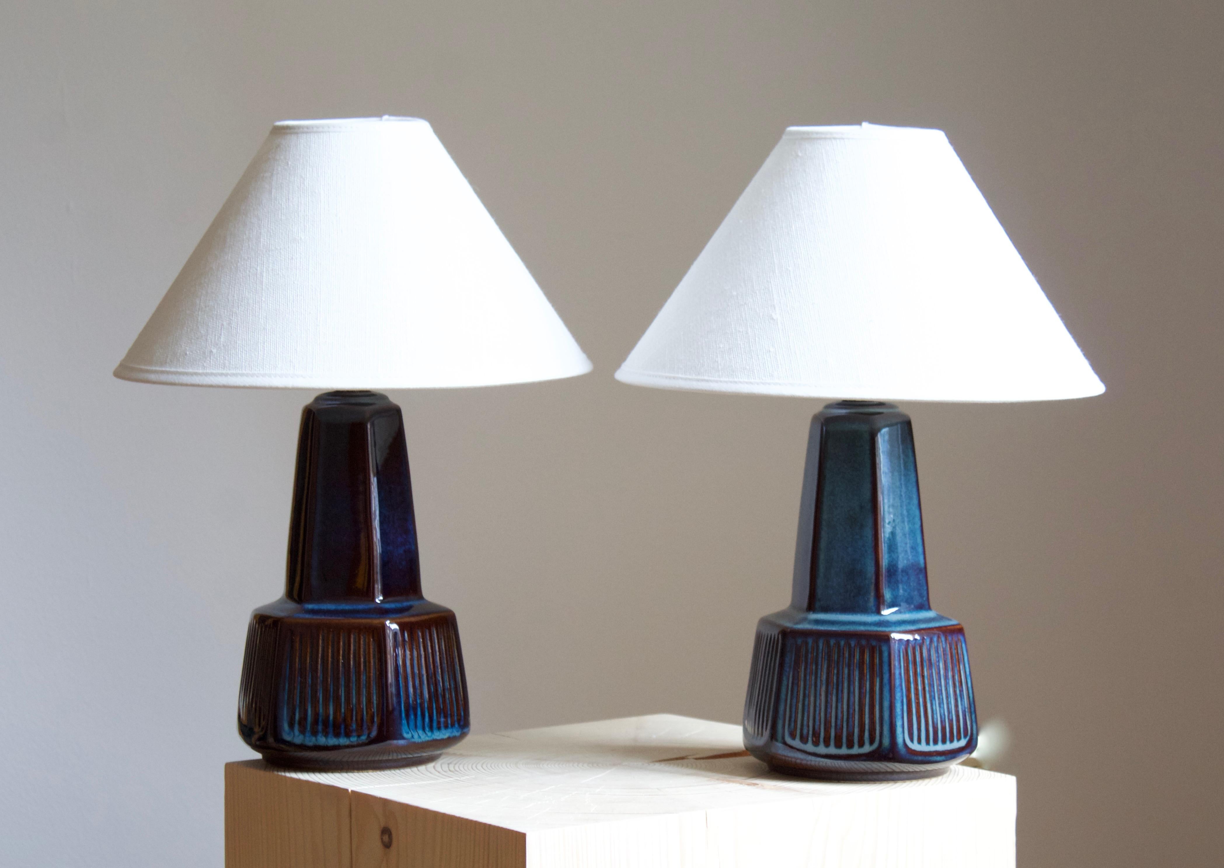 A pair of table lamps produced by Søholm Keramik, located on the island of Bornholm in Denmark. Features a highly artistic glazed and incised decor. 

Sold without lampshade. Stated dimensions exclude the lampshade. Height includes socket.

Glaze