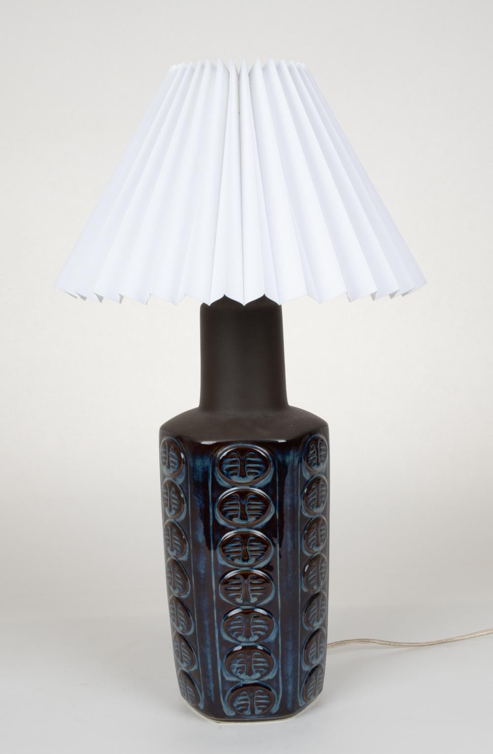 A gorgeous Scandinavian midcentury table lamp designed by Einar Johansen for Soholm in beautiful mottled blue glaze with repeated organic inspired medallion designs. Signed underneath. 
Does not include lampshade.