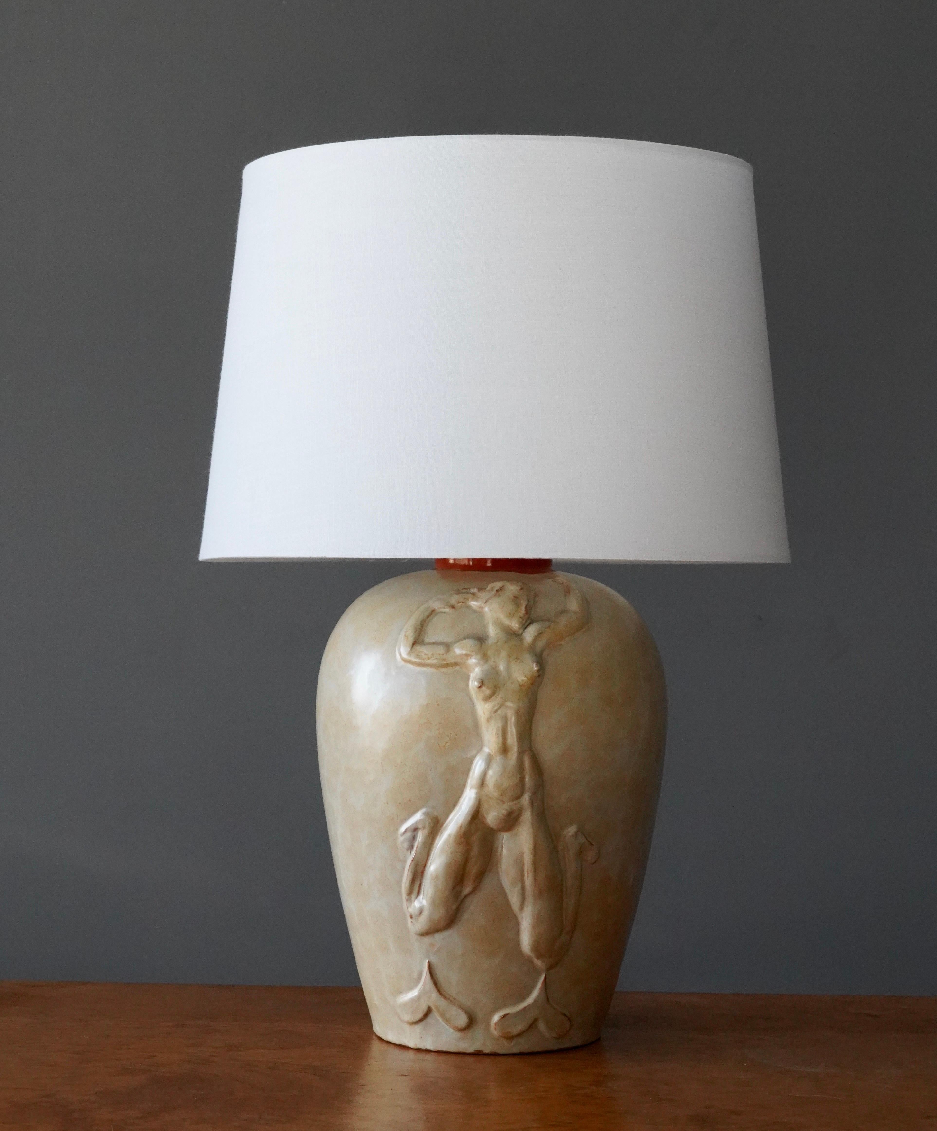 A table lamp, designed by Swedish Sculptor Einar Luterkort (1905 - 1981).
 
Motif to base illustrating a female nude form.

Dimensions listed are without lampshade. 
Dimensions with shade: height is 21.5 inches, width is 15 inches.
Dimensions
