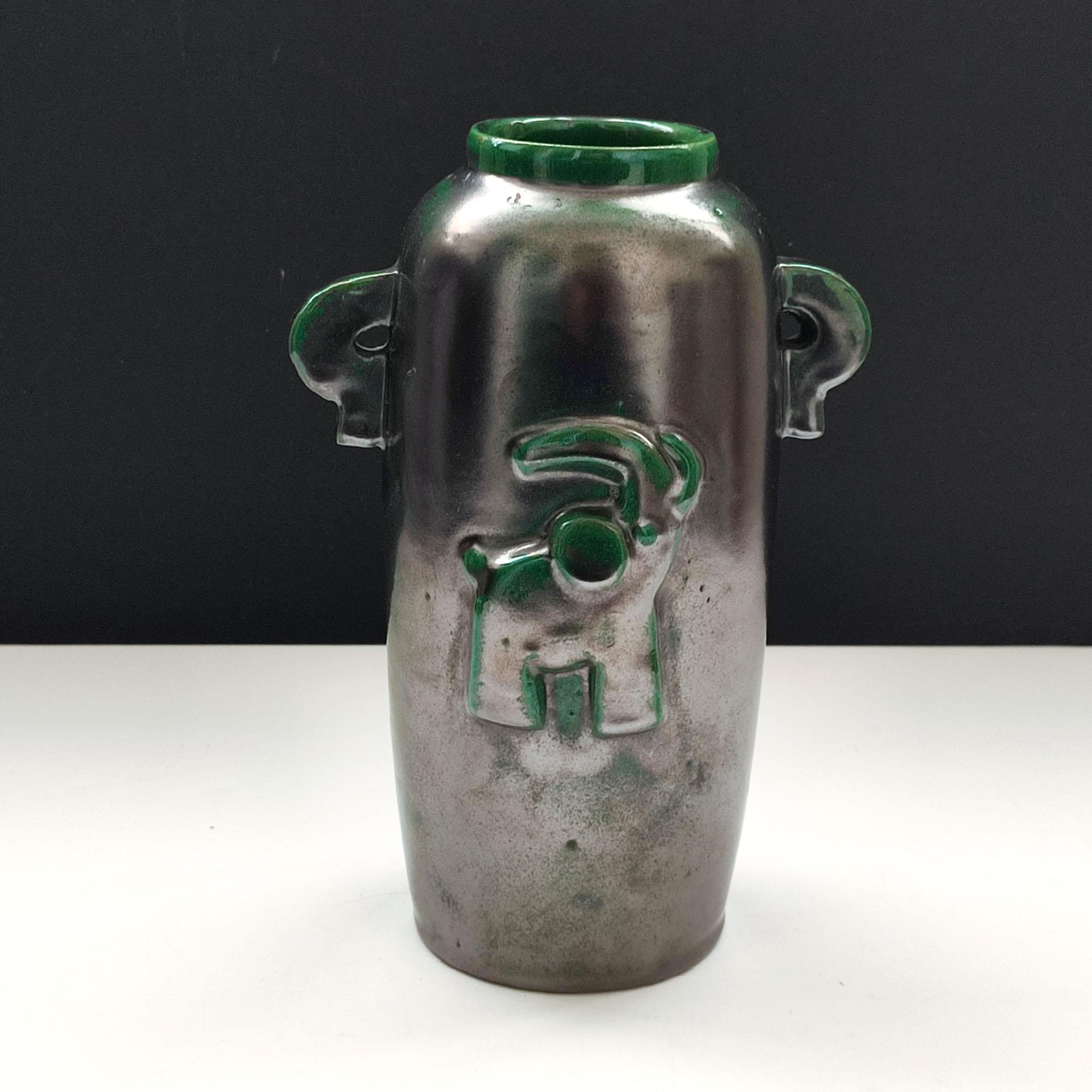 A green and black luster, glazed earthenware vase designed by Einar Luterkort for Motala Lervarufabrik in the 1930s. Clean Art Deco desgn featuing a stylized elephant in relief on the front. Two small decorative handles on sides.
Vey good